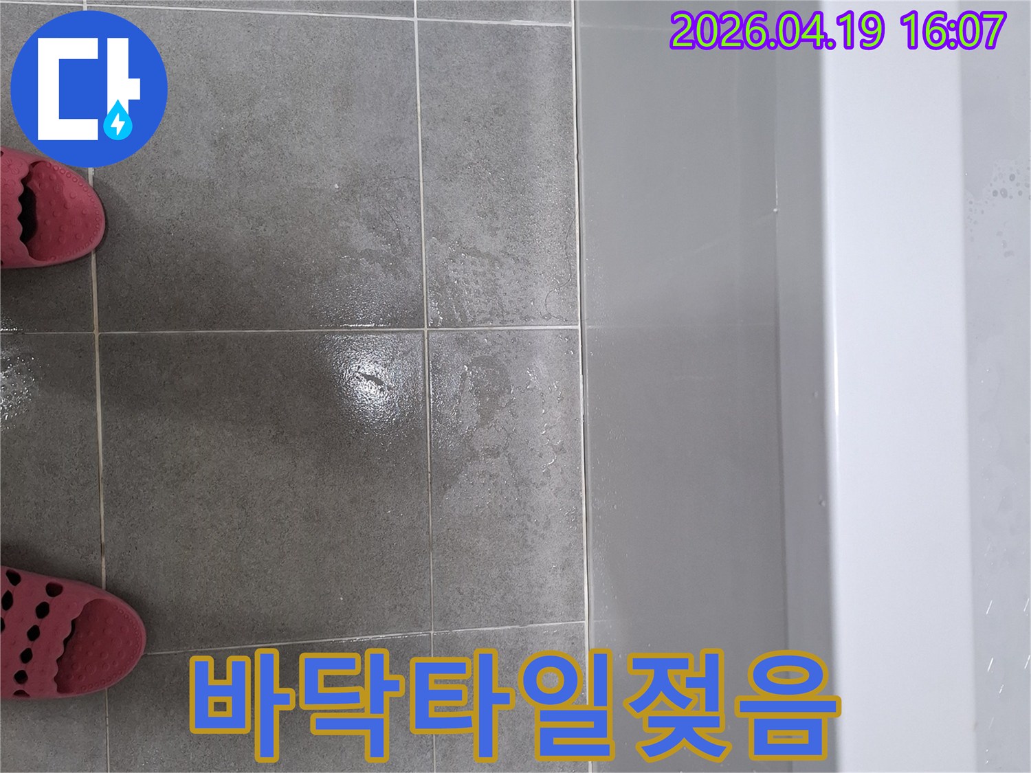 욕조 주변의 매지 손상으로-인해 바닥 타일에 물이 고여있는-누수 현장의 증거 사진입니다.