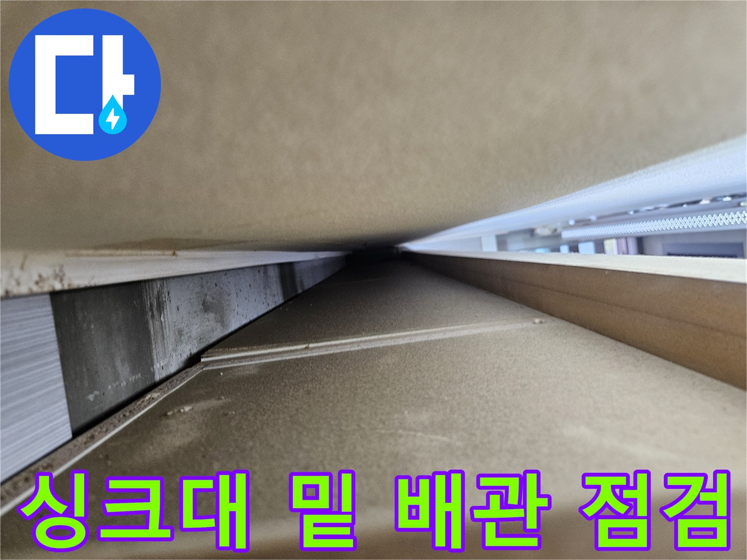 싱크대 하단 좁은 공간의 배관 구조와 상태를 촬영한 사진입니다.