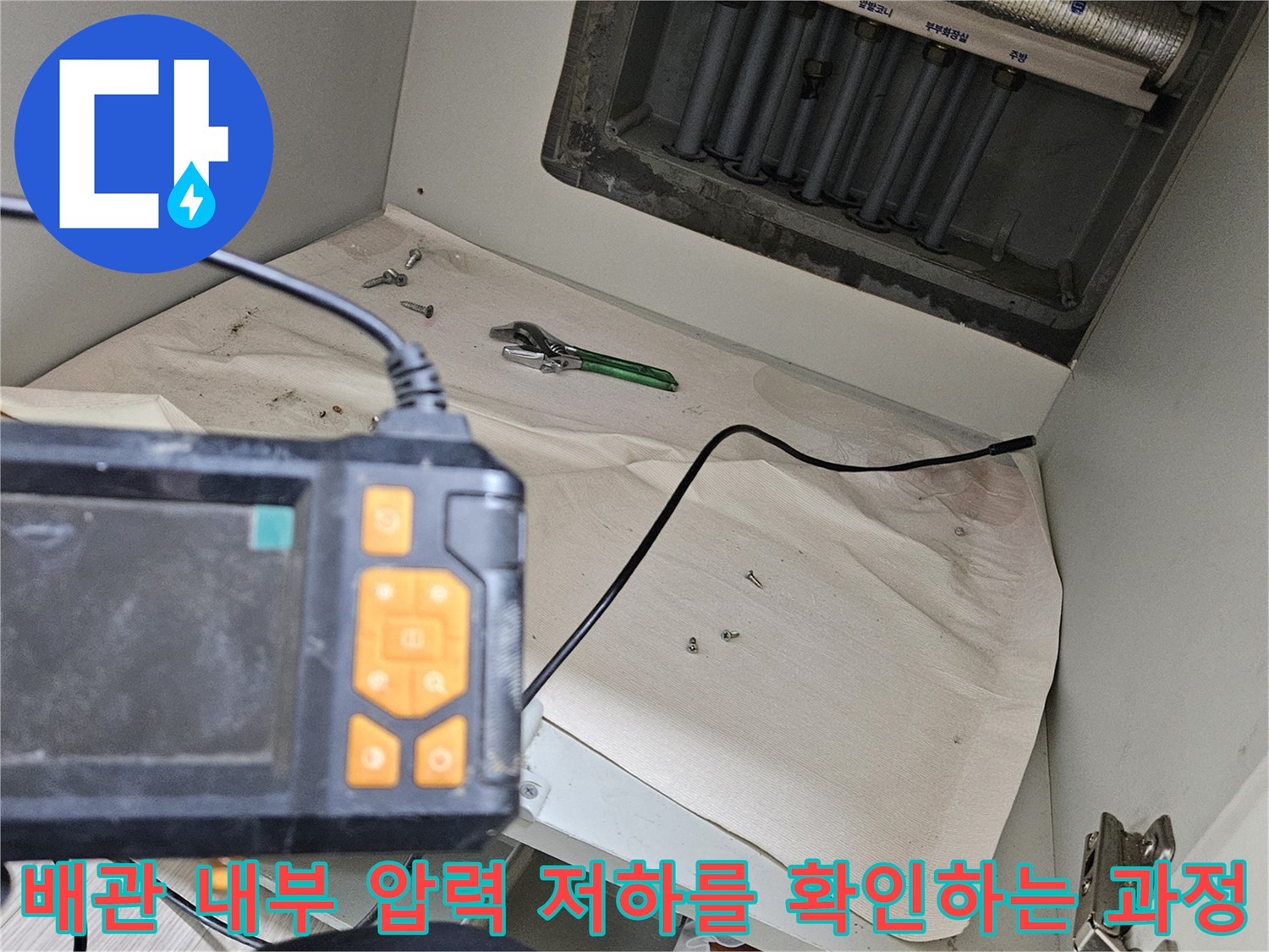 싱크대 하부 분배기에 디지털 압력계를 연결하여 누수 여부를 정밀하게 측정하고 있습니다.