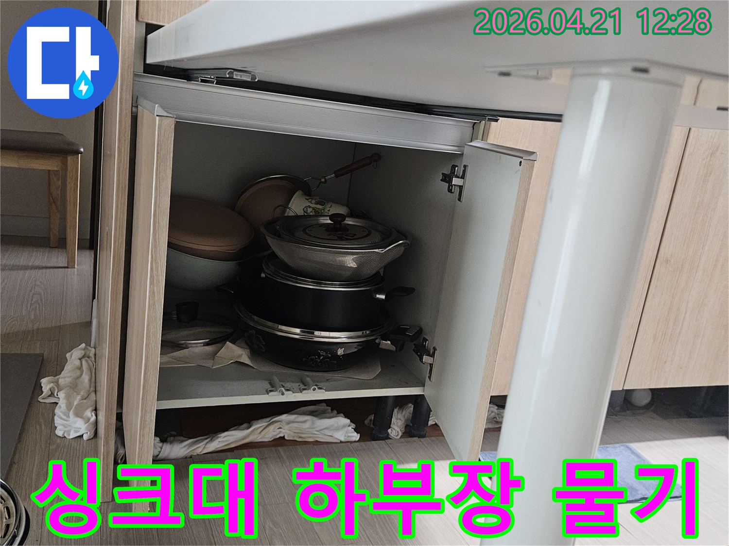 싱크대 하부장 내부에서 발견된-물기로 젖은 주방용품과-배관 노후로 인한 누수 현장