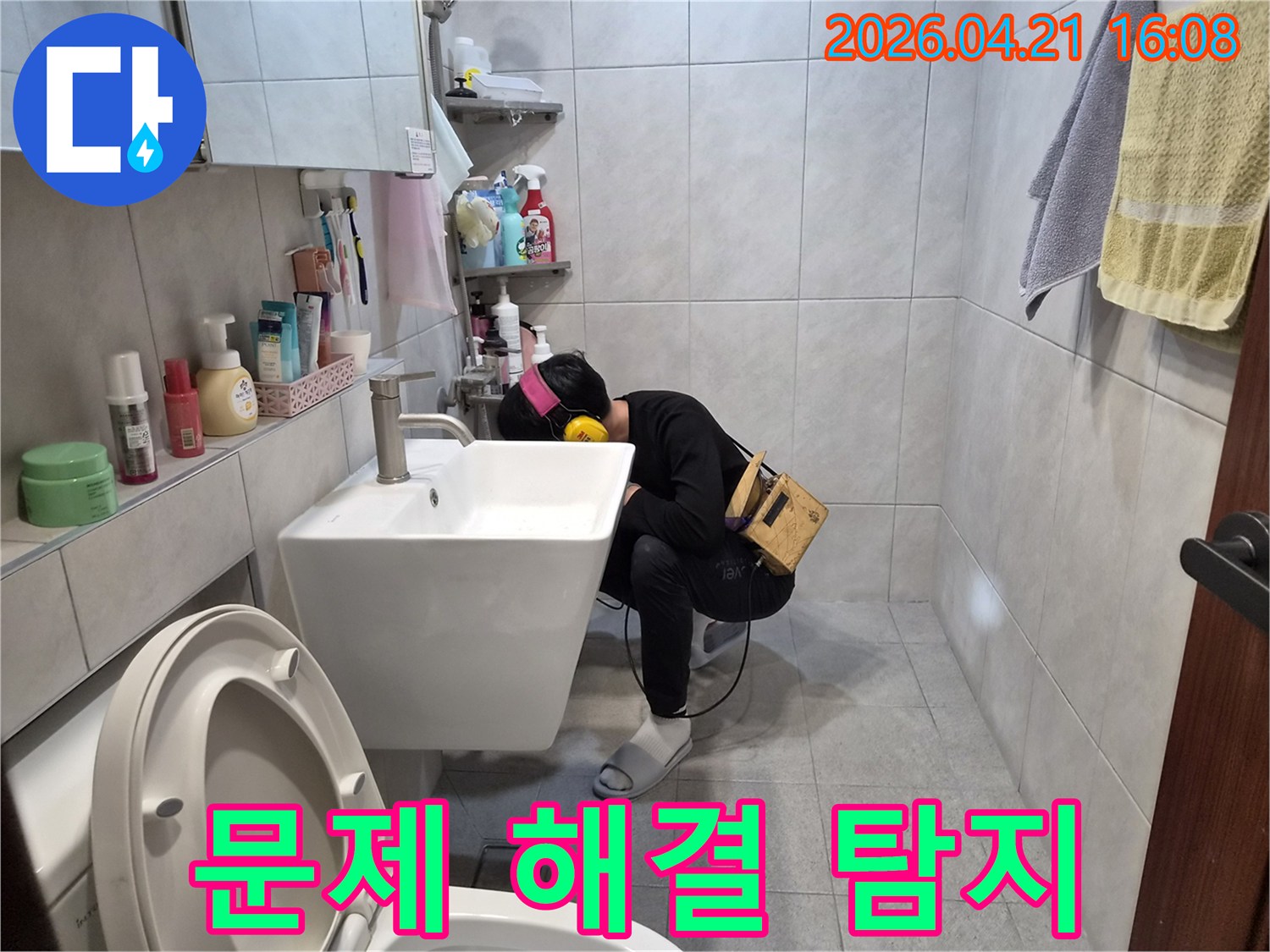 전문 엔지니어가 욕실에서-청음 장비를 이용해-배관의 미세한 누수음을 듣고-문제를 해결하기 위해 누수 지점을 찾아내고 있습니다