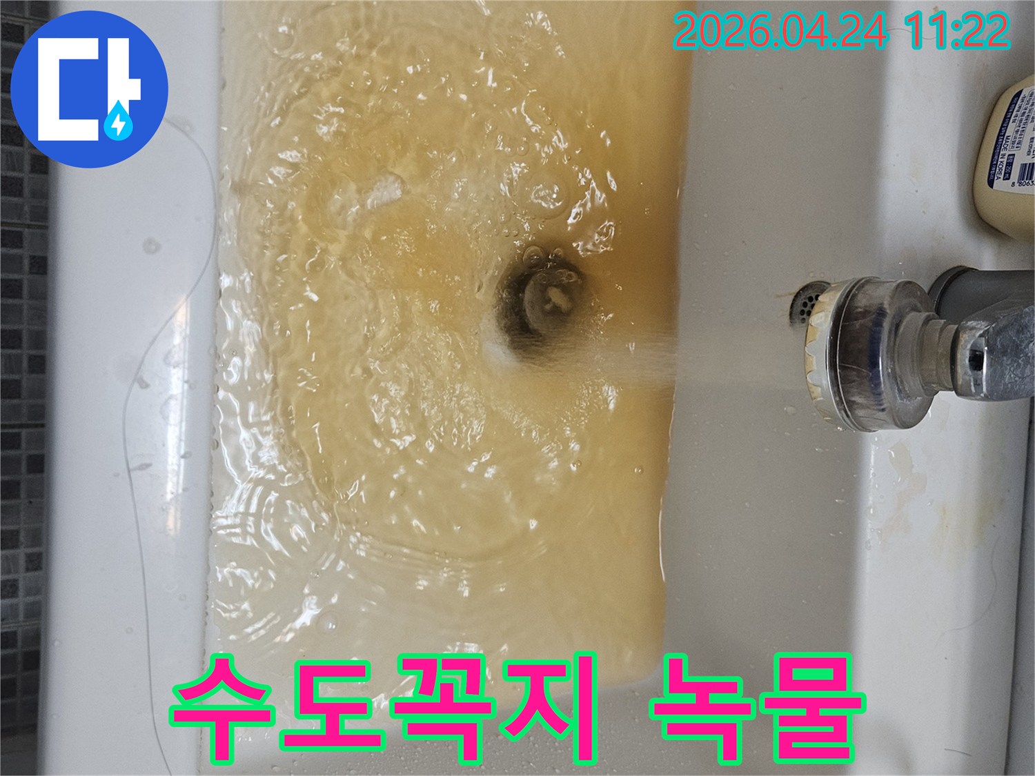 녹물이 흐르는 수도꼭지와-오염된 물로 채워진 세면대의 모습입니다-수도관 문제의 심각성을 알 수 있습니다.