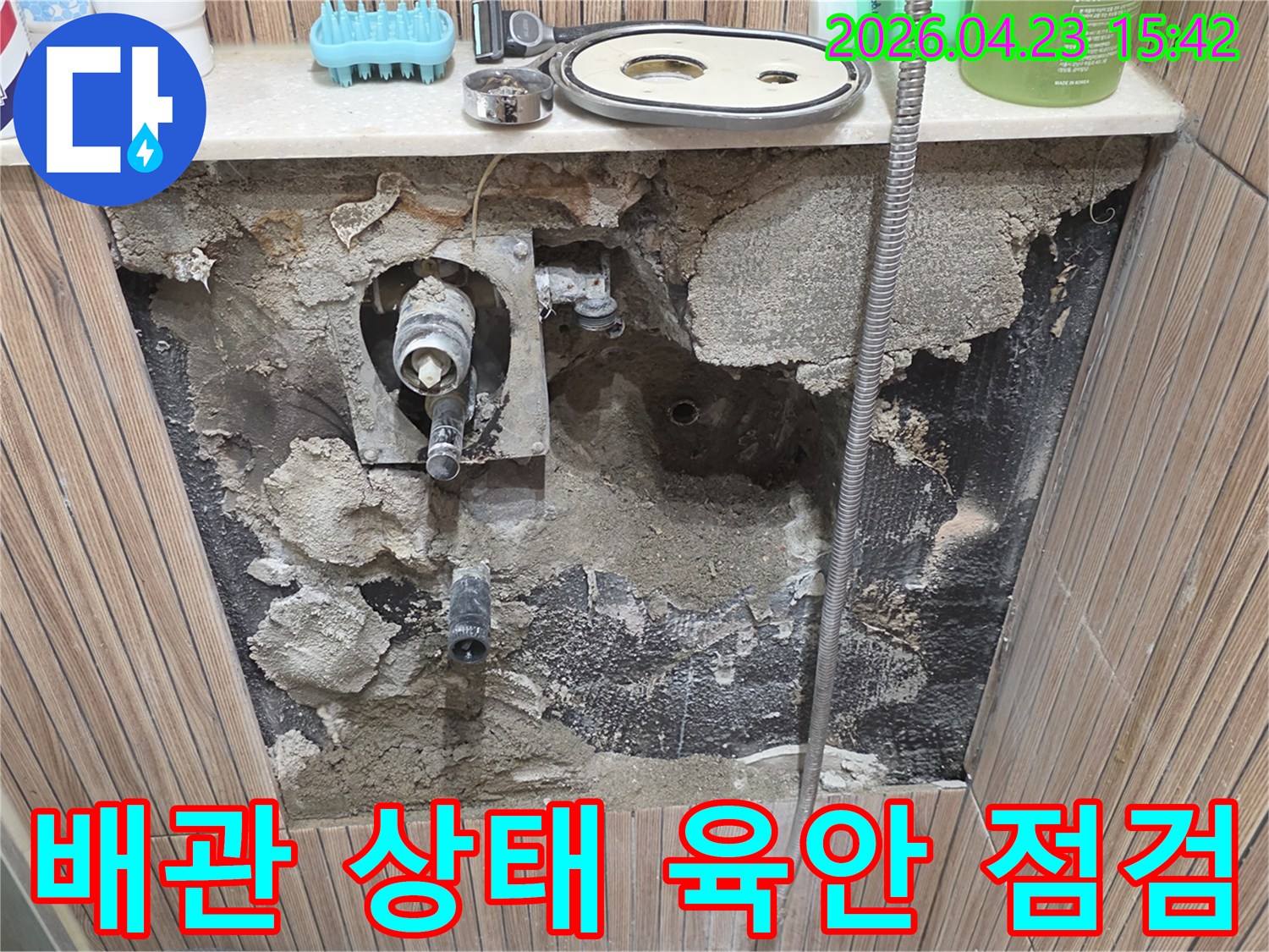 노원구 상계동 아파트 욕실 누수 현장에서-타일을 제거하고-내부 배관의 상태를 육안으로 면밀히 점검하는 사진입니다.