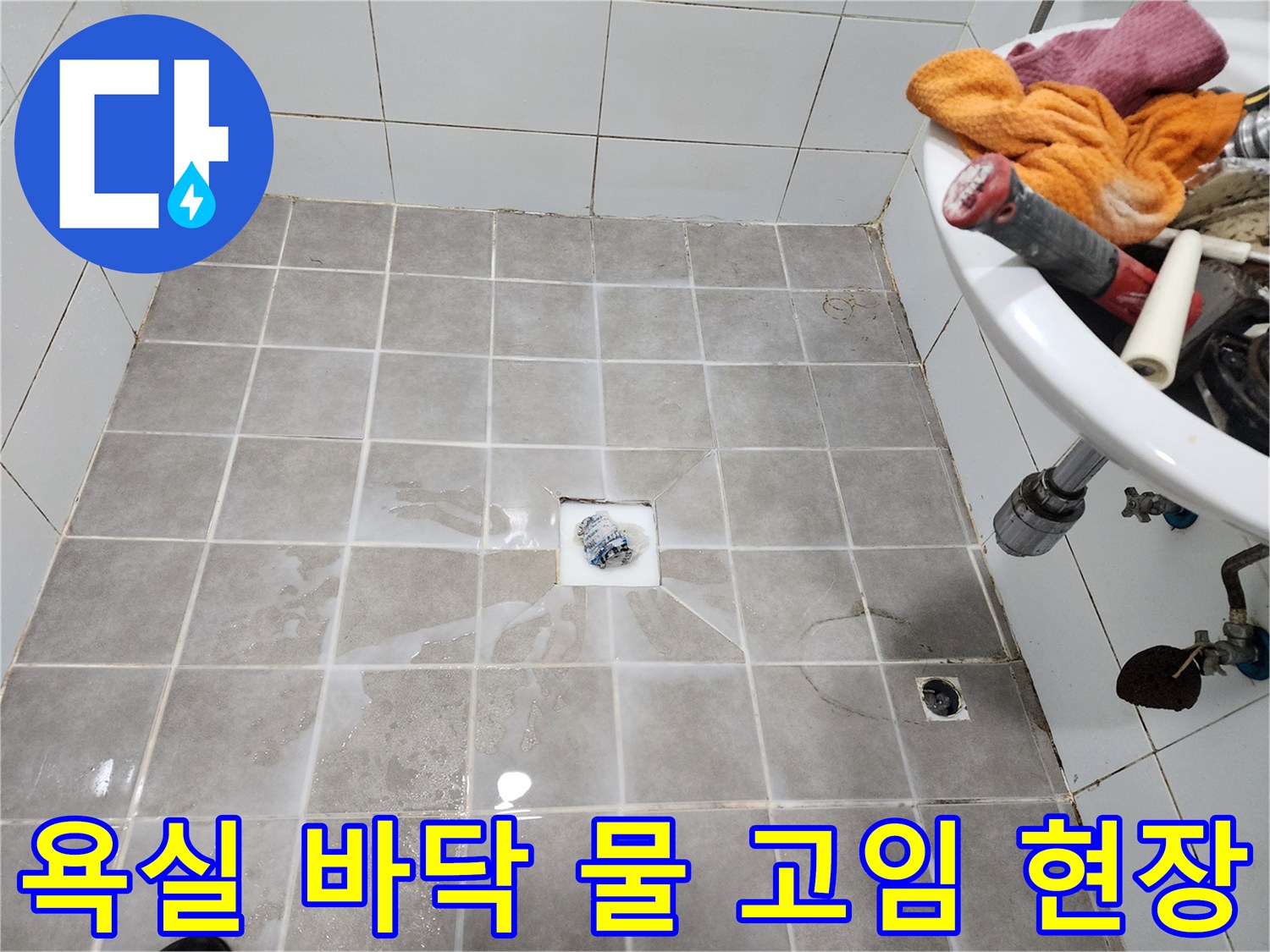 욕실 바닥 타일 위에-물이 흥건하게 고여-누수 문제를 보여주는-현장 점검 사진입니다