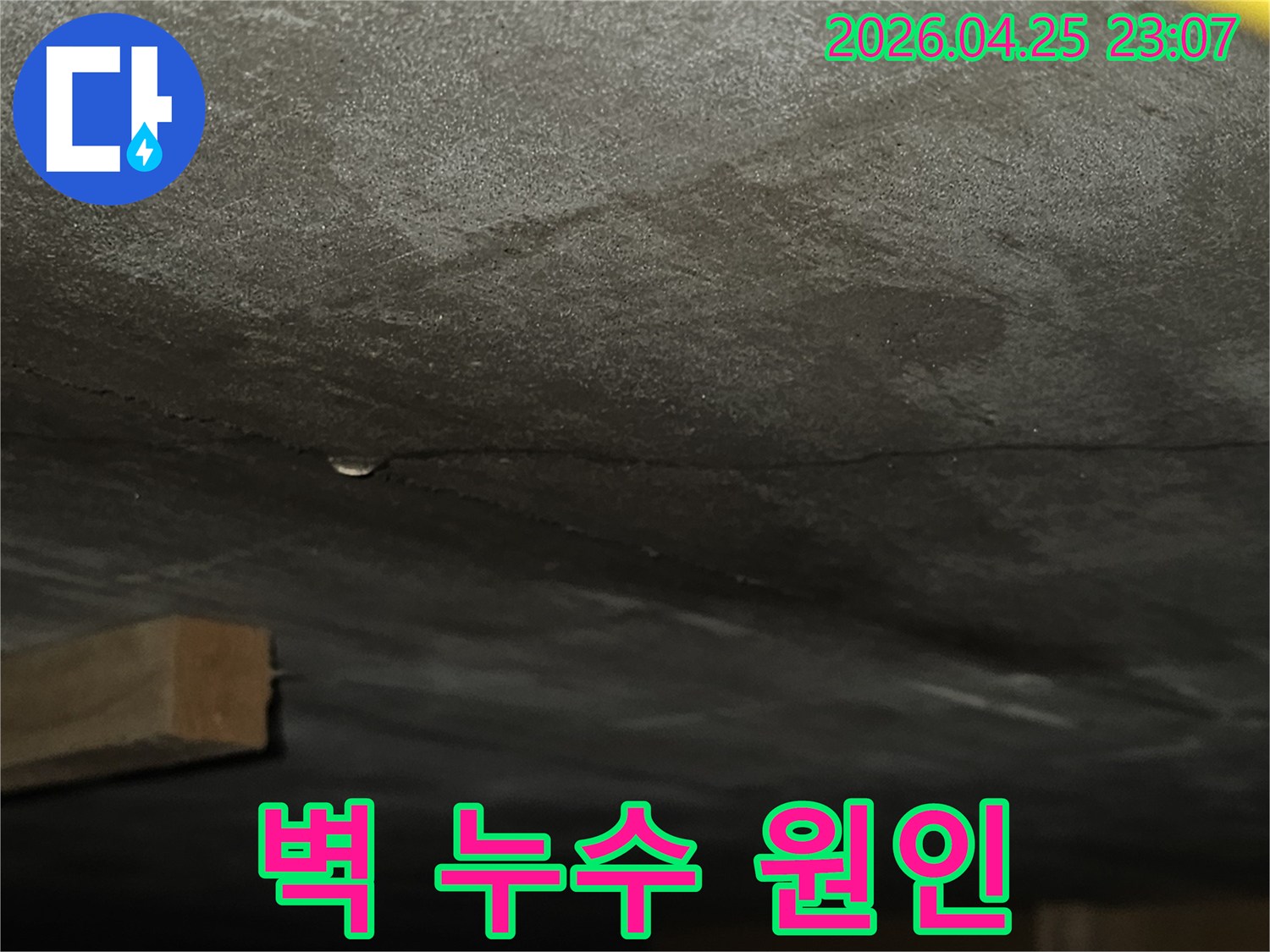 벽면에 생긴 균열을 따라 물기가 스며들어 어둡게 변색된-누수 현장의 상세 모습으로-원인 분석이 필요한 상황