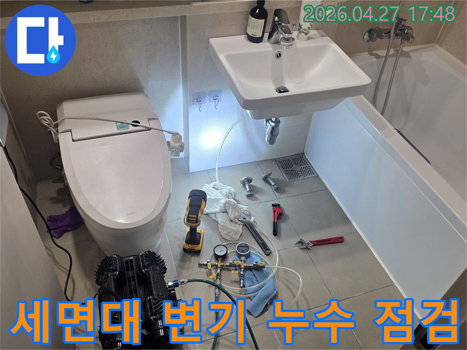 이 이미지는 화성 동탄 지역의 욕실에서-세면대와 변기 주변의 누수 여부를-압력 테스트 장비로 면밀히 점검하는-전문가의 작업 현장입니다.