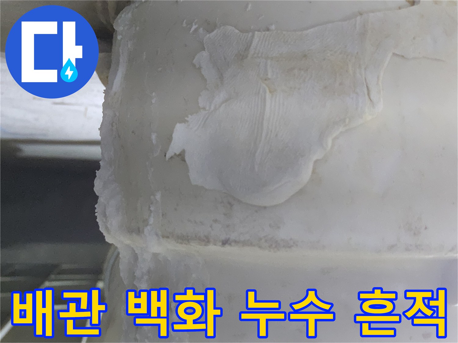 오랜 기간 물이 새면서-하얗게 굳어버린-배관 주변의-석회질 침전물과-물때 흔적을-보여주는 이미지입니다.
