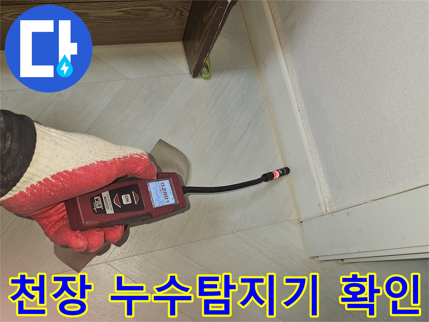 숙련된 전문가가 누수 탐지 장비로 천장 모서리 부근의 미세한 누수 지점을 확인하는 모습
