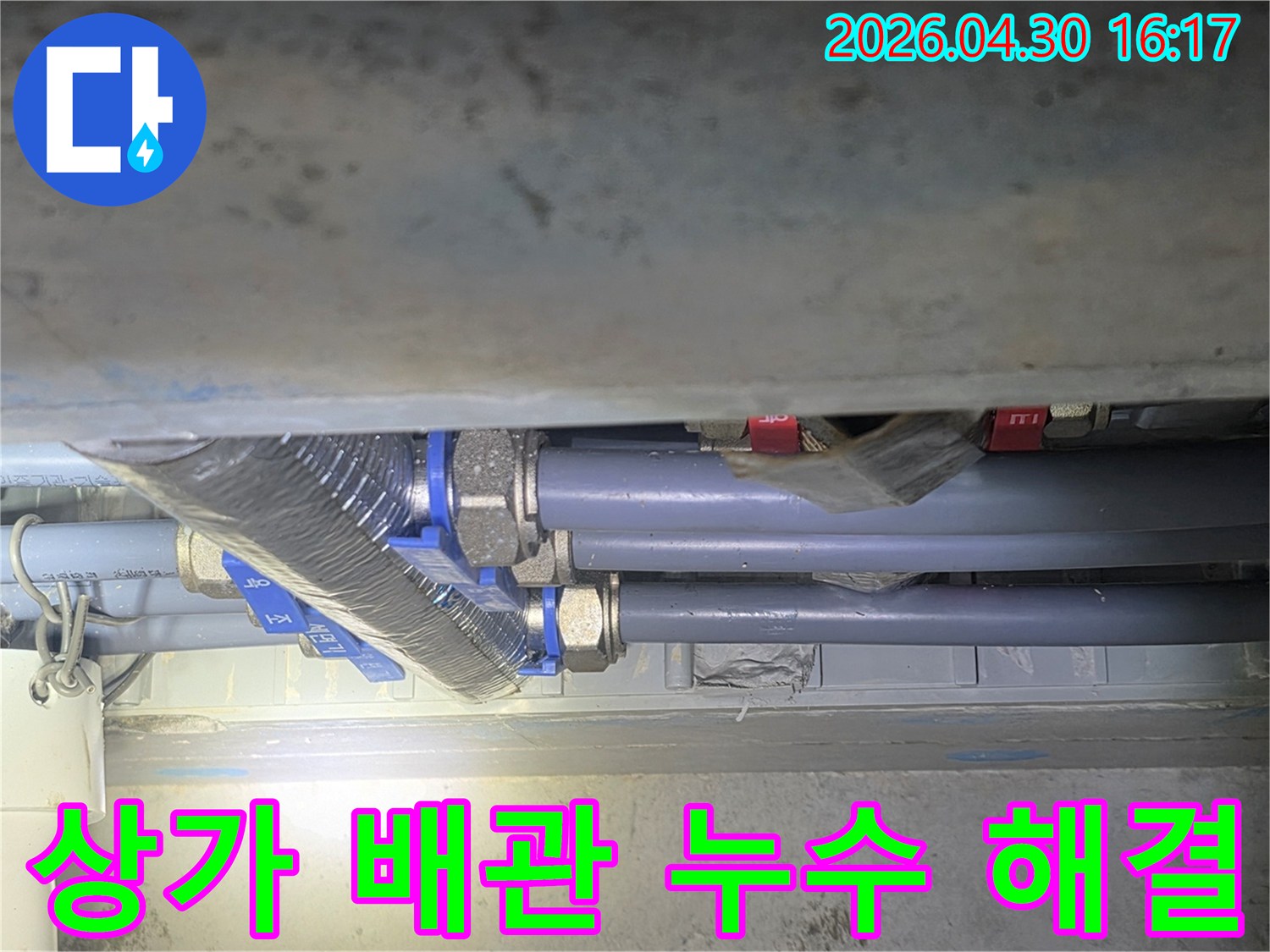 누수 전문 엔지니어가-상가 수도 배관의-복잡한 연결 부위를-점검하여-누수 문제를-해결하는 모습