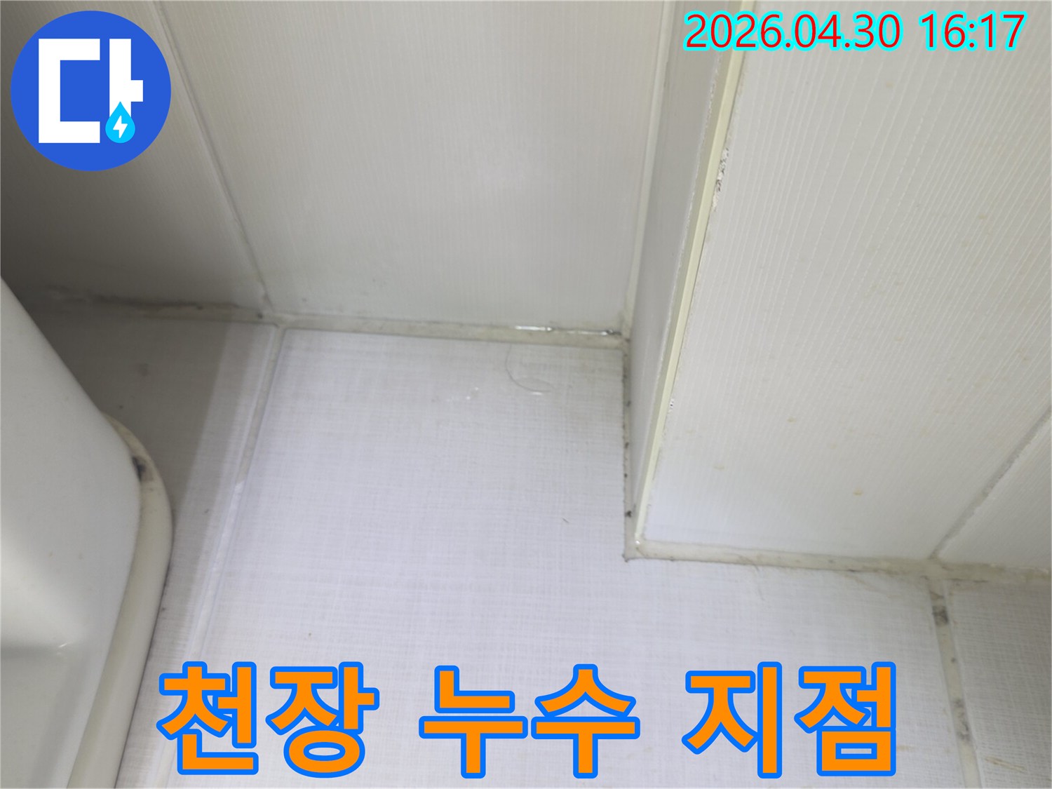 천장과 벽의 경계에서 물이 새어 나와-벽지가 젖어있는 상태를 보여주는-누수 발생 현장의 증거 사진