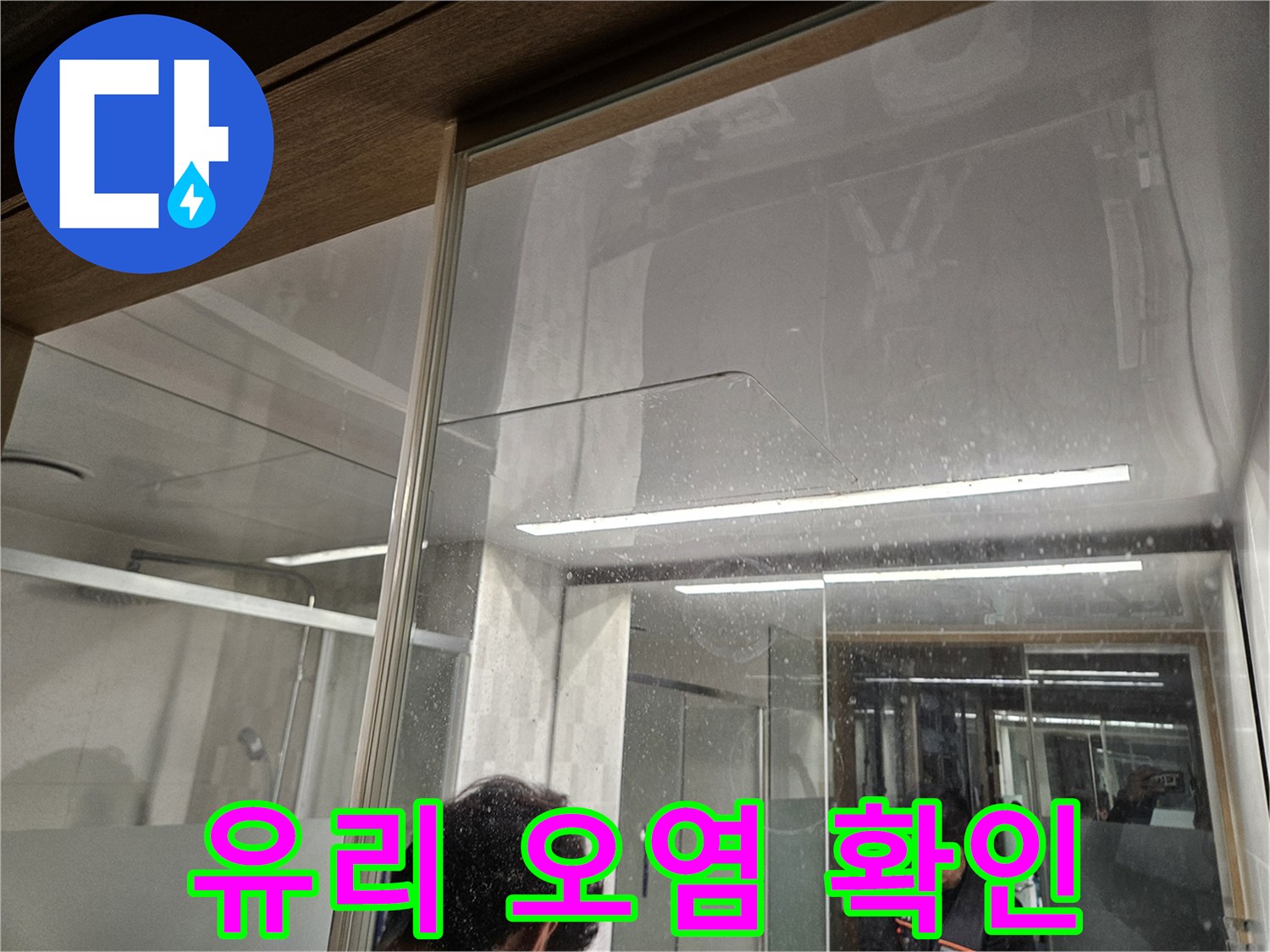 유리-벽면에-남은-물-자국과-오염-흔적-누수-전문가가-누수-피해-상황을-조사하는-모습