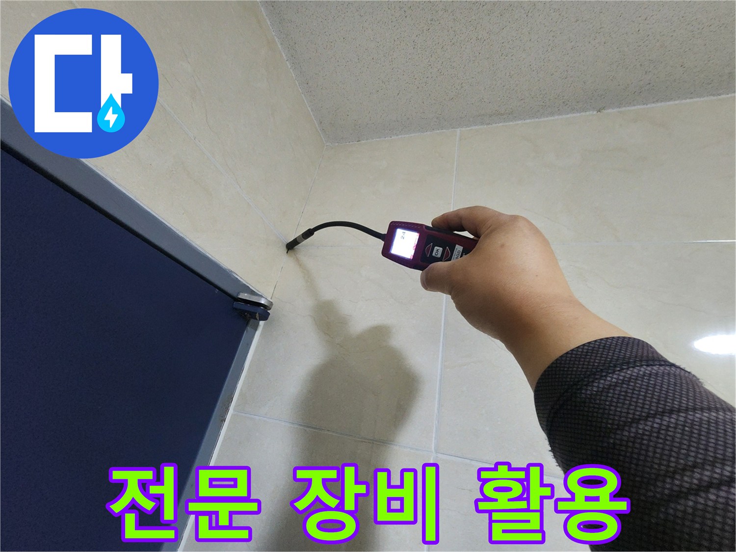 누수 전문 엔지니어가-첨단 탐지 장비를 사용하여-타일 벽면의 미세한 누수 흔적을-정확하게 찾아내고 있습니다.