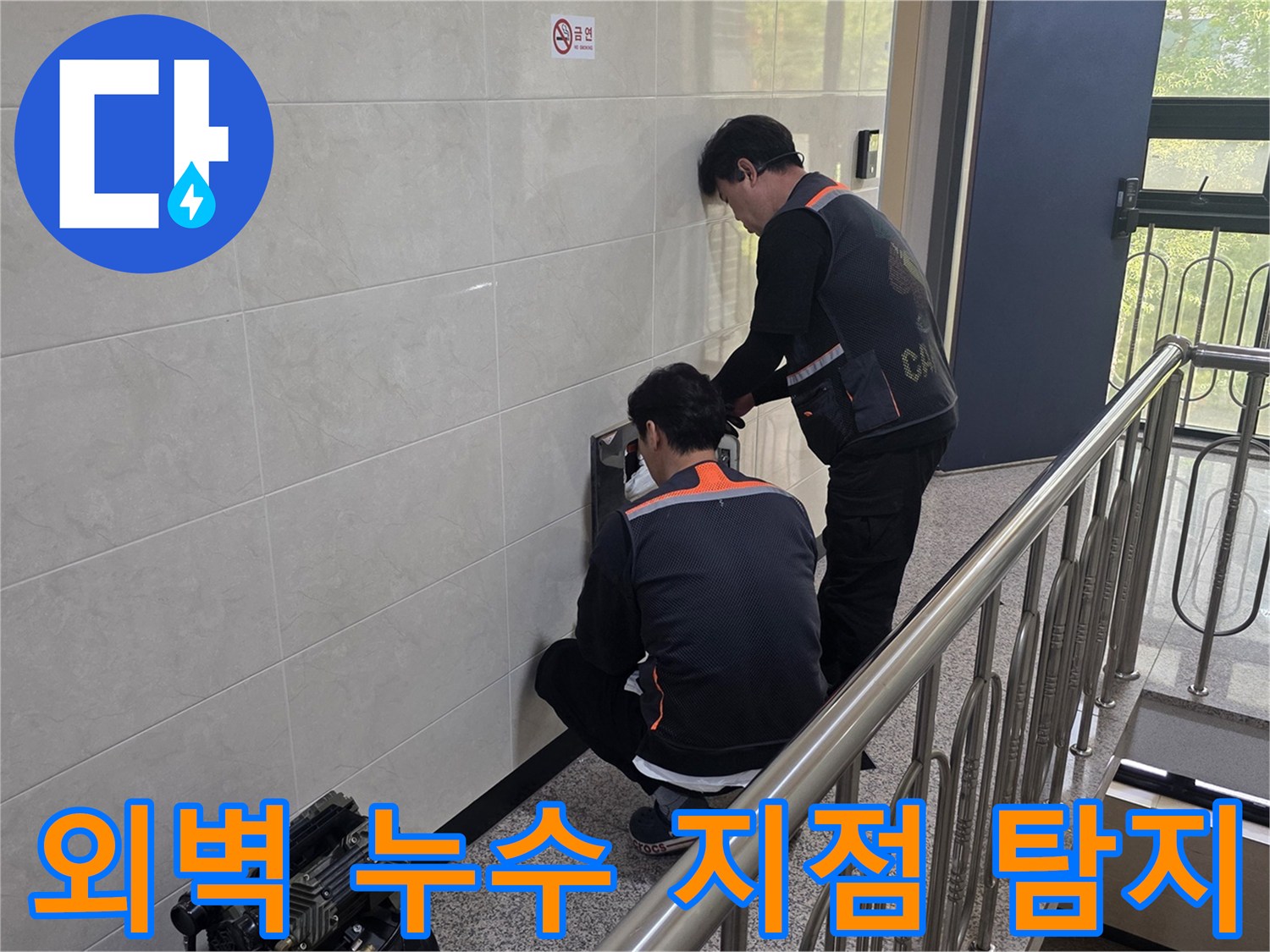 두 명의 전문 기술자가 건물 벽면의 외벽 누수 의심 지점을 정밀하게 탐지하고 있습니다-건물 안전과 내구성을 위한 정확한 원인 파악 작업입니다.