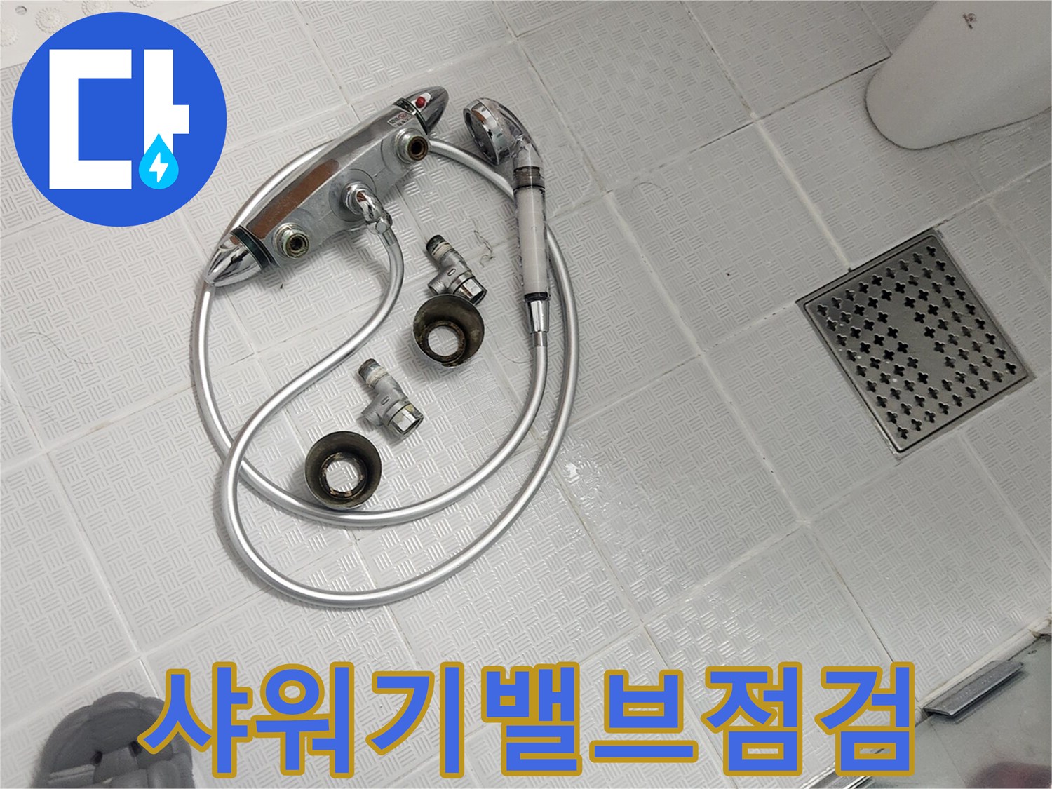 욕실 바닥에 놓인 분리된 샤워기 밸브와 호스-헤드 교체와 함께 밸브 점검을 위한 작업