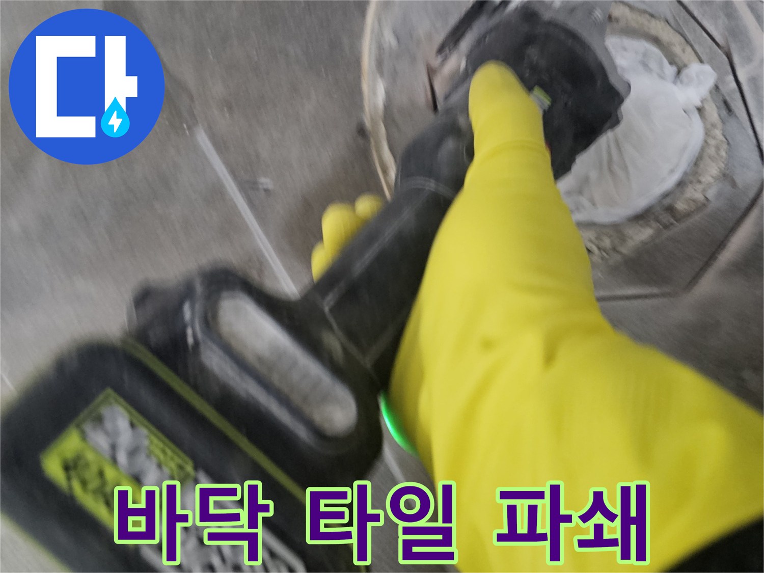 노란색 작업 장갑을 착용한-전문가가-전동 공구로-하수구 주변의 바닥 타일을-세심하게 파쇄하는 과정입니다.