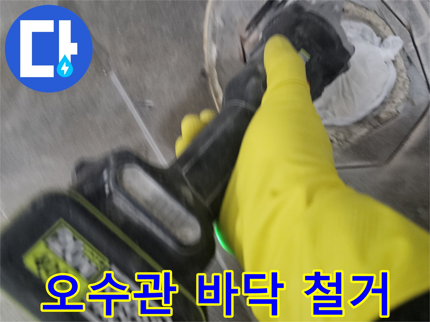 노란색 장갑을 착용한-작업자가-전동 커팅기로-오수관 주변의 바닥을-정밀하게 철거하여-배관을 확인하는 모습입니다.