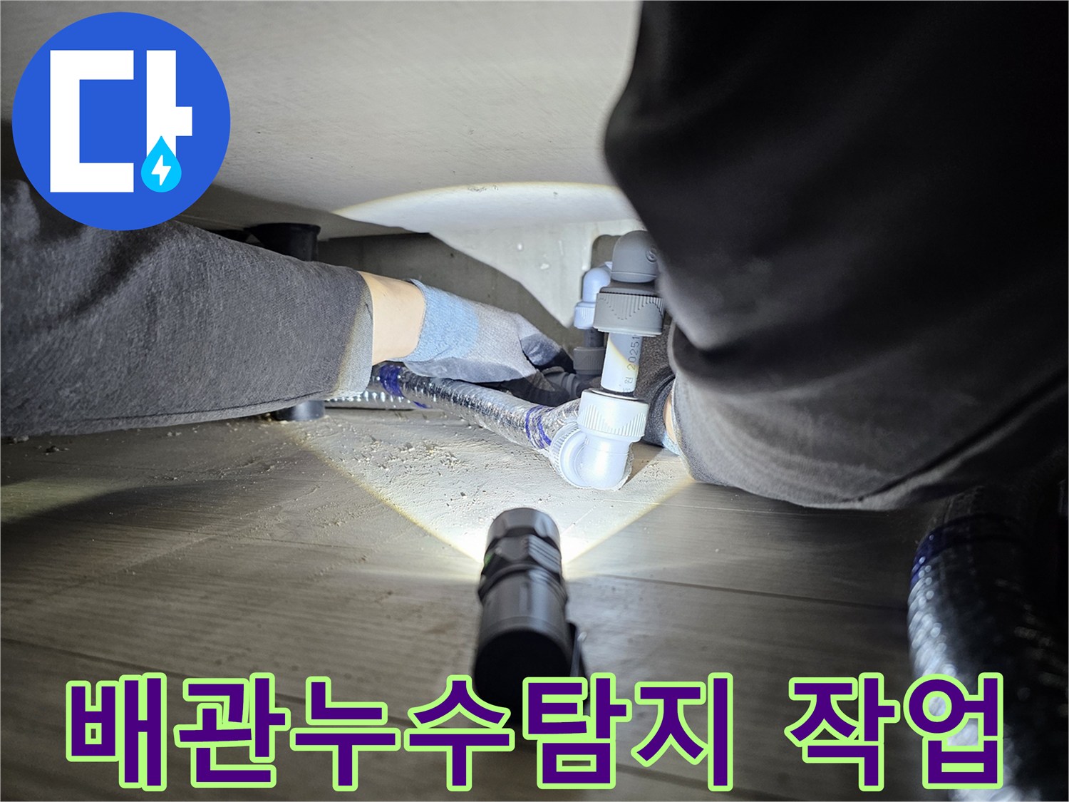 누수-탐지-전문가가-어두운-공간에서-배관-연결부를-확인하는-모습