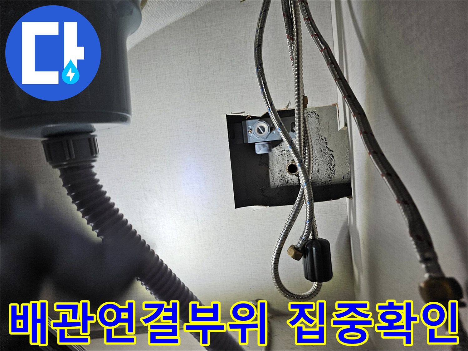 주방 싱크대 하부장 내부의-배관 연결 부위를-집중적으로 확인하여-누수 여부를-점검하는 모습입니다.