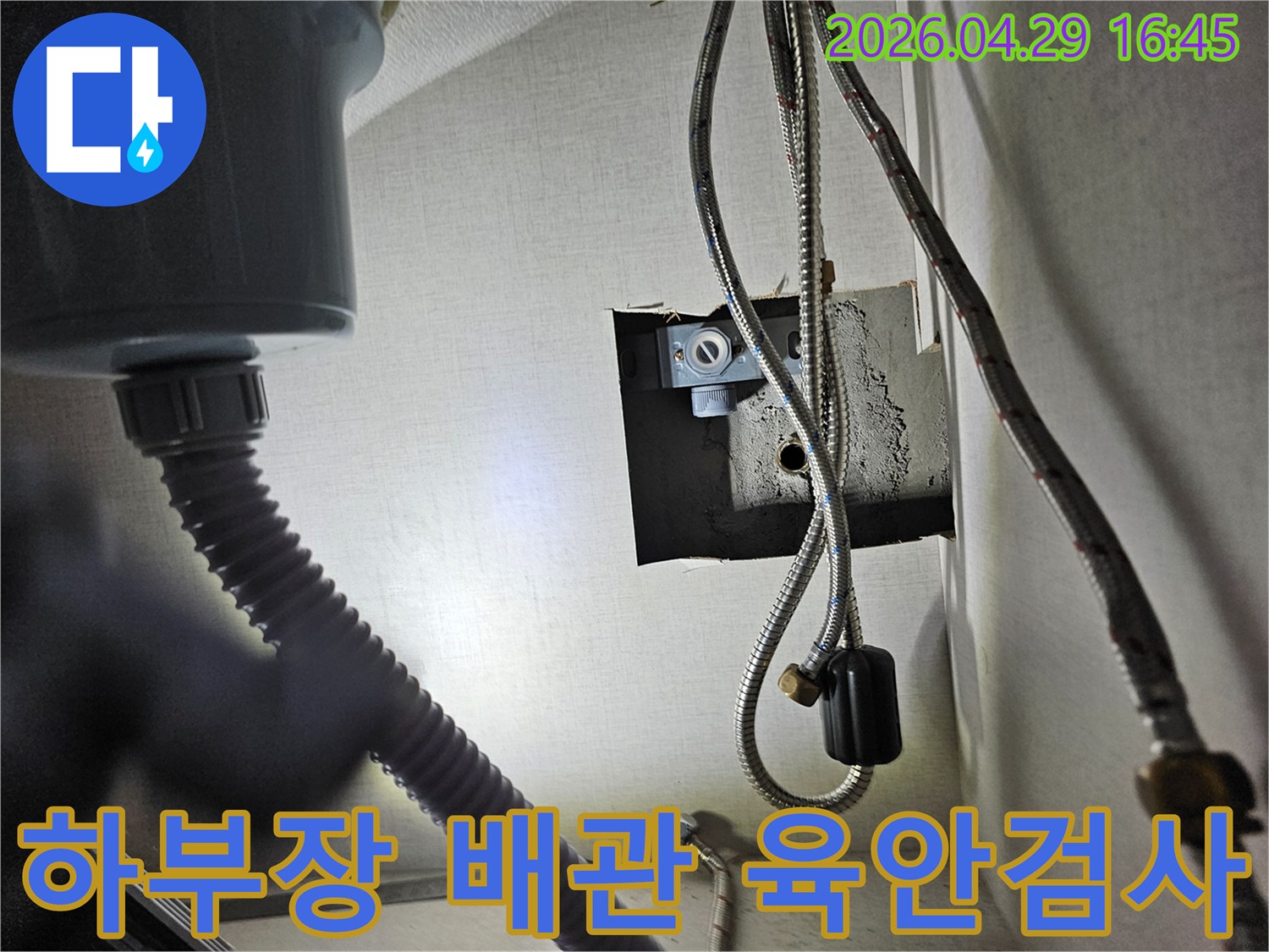 주방 싱크대 하부장 내부의-수도 배관과-연결 부위를-육안으로-꼼꼼히 검사하는 장면입니다.