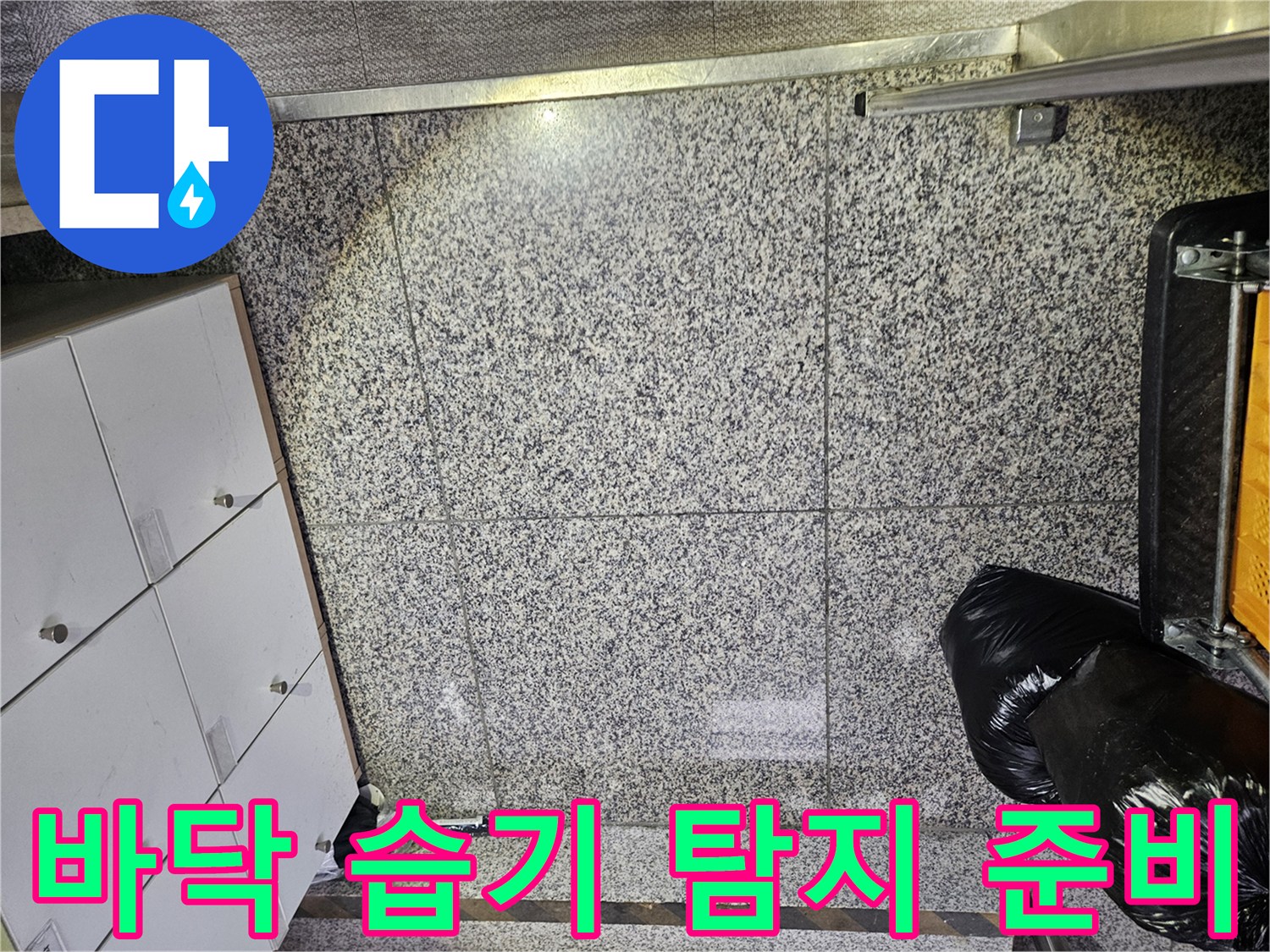 포천 아파트의 바닥 타일에서-누수로 인한 물기 흔적을 발견하고-정확한 누수 지점을 찾기 위한-전문가의 면밀한 점검이 이루어지고 있습니다