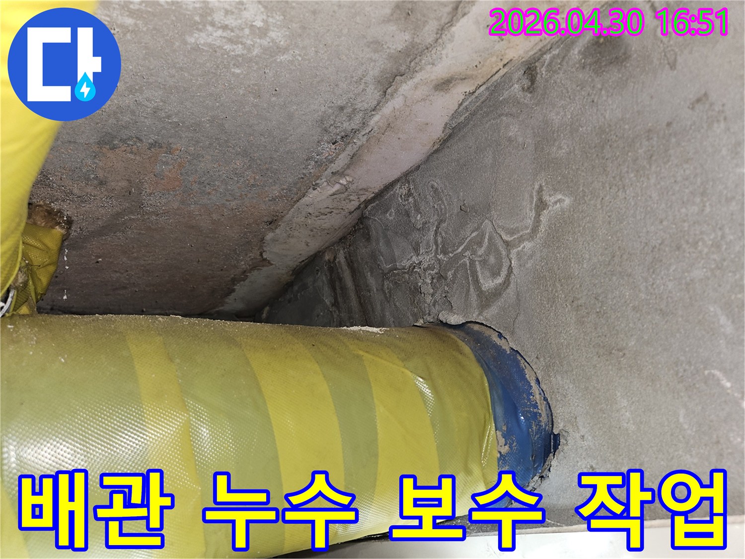 노란색 배관 주변-콘크리트 벽에 나타난-하얀색 물자국과-습기 흔적을 담은-누수 공사 전 현장 모습