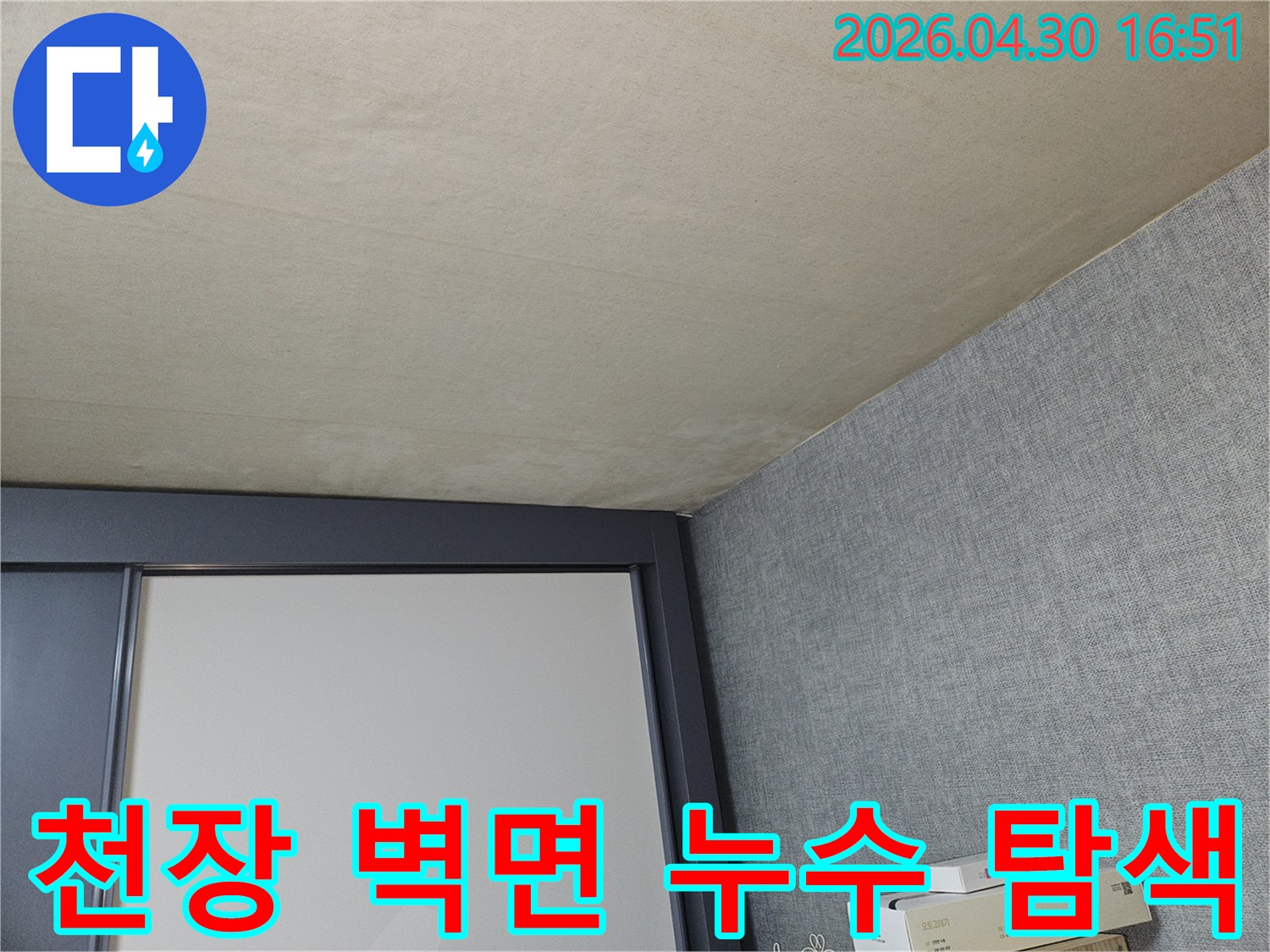 이 사진은-천장과-벽면의-접합부에서-누수-징후를-찾아내기-위해-전문가가-집중적으로-탐색하는-모습을-보여줍니다