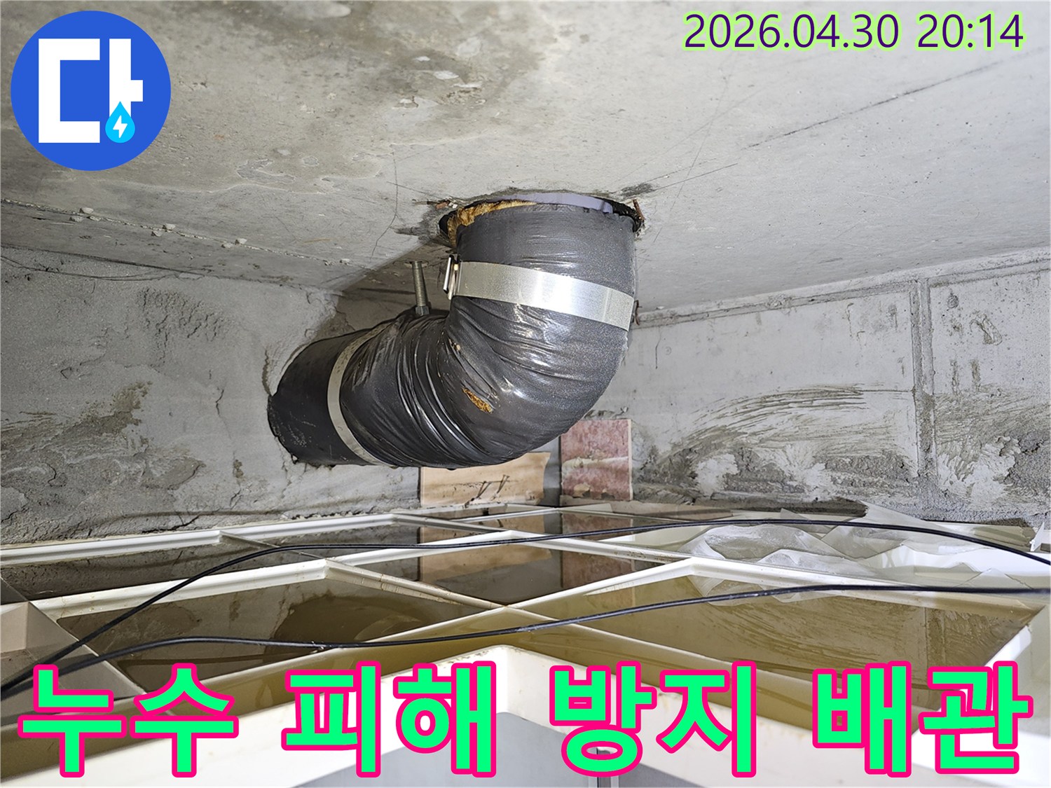 아파트 천장 누수 현장에서-추가적인 물 피해를 막기 위해-설치된 임시 배관의 모습입니다.