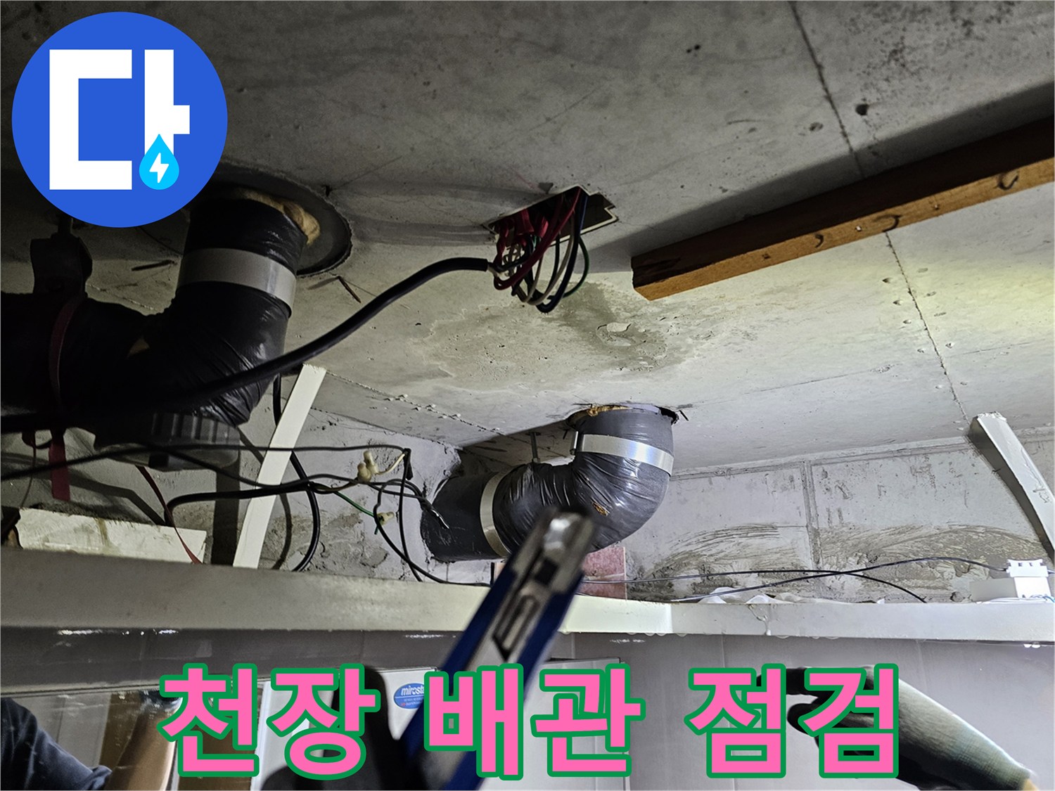 콘크리트 천장 아래- 복잡하게 연결된 배관과- 전기 배선을 정밀하게 점검하는 모습