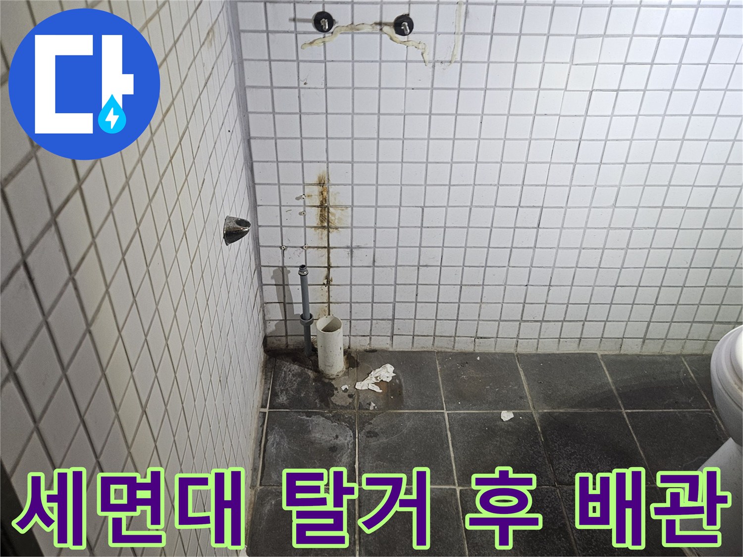 세면대 탈거 작업 후-욕실 벽면에 노출된-수도 배관 연결부와-주변의 누수 흔적을-정밀하게 검사하는-누수 전문가