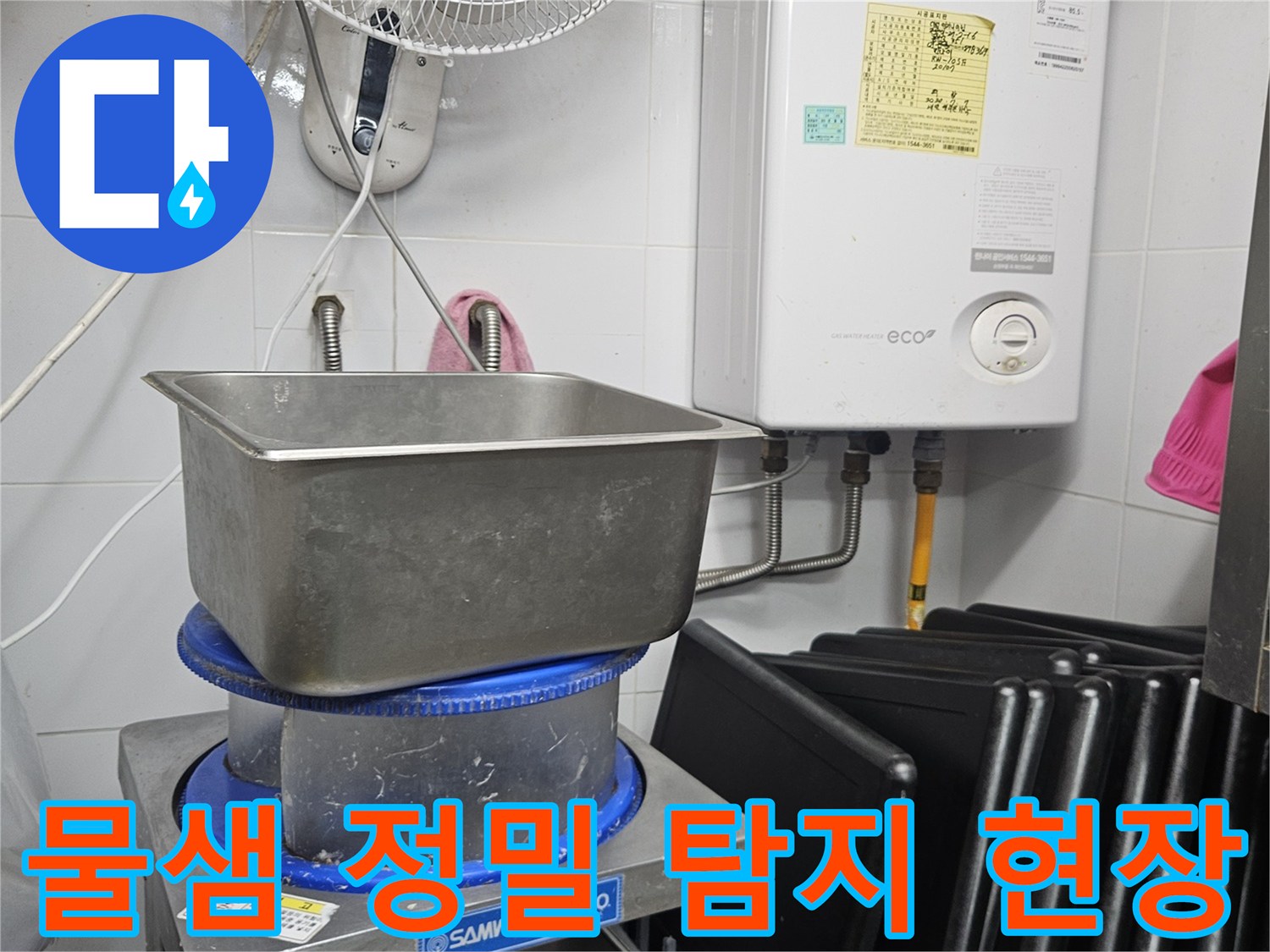 이 이미지는 보일러와 싱크대-그리고 다양한 배관이 있는 공간에서-물샘 현상의 원인을 찾기 위해 정밀 탐지 작업을 수행하는 모습을 담고 있습니다.