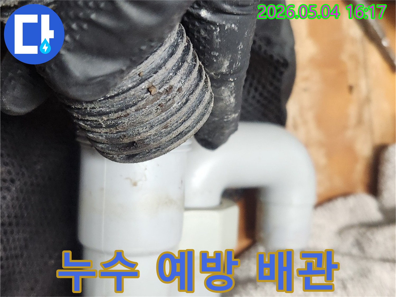 누수 예방을 위해-전문가가 싱크대 S트랩을-탈거하여-내부 상태를 점검하고 청소하는 사진입니다
