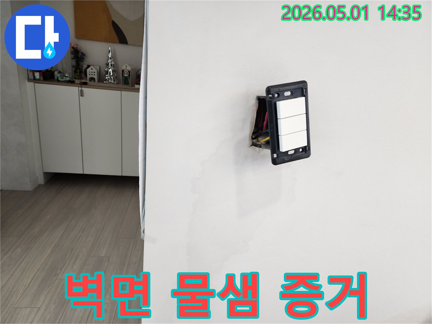 누수로 인해 벽지가 손상되었고-스위치 근처에 물기가 번져 있습니다