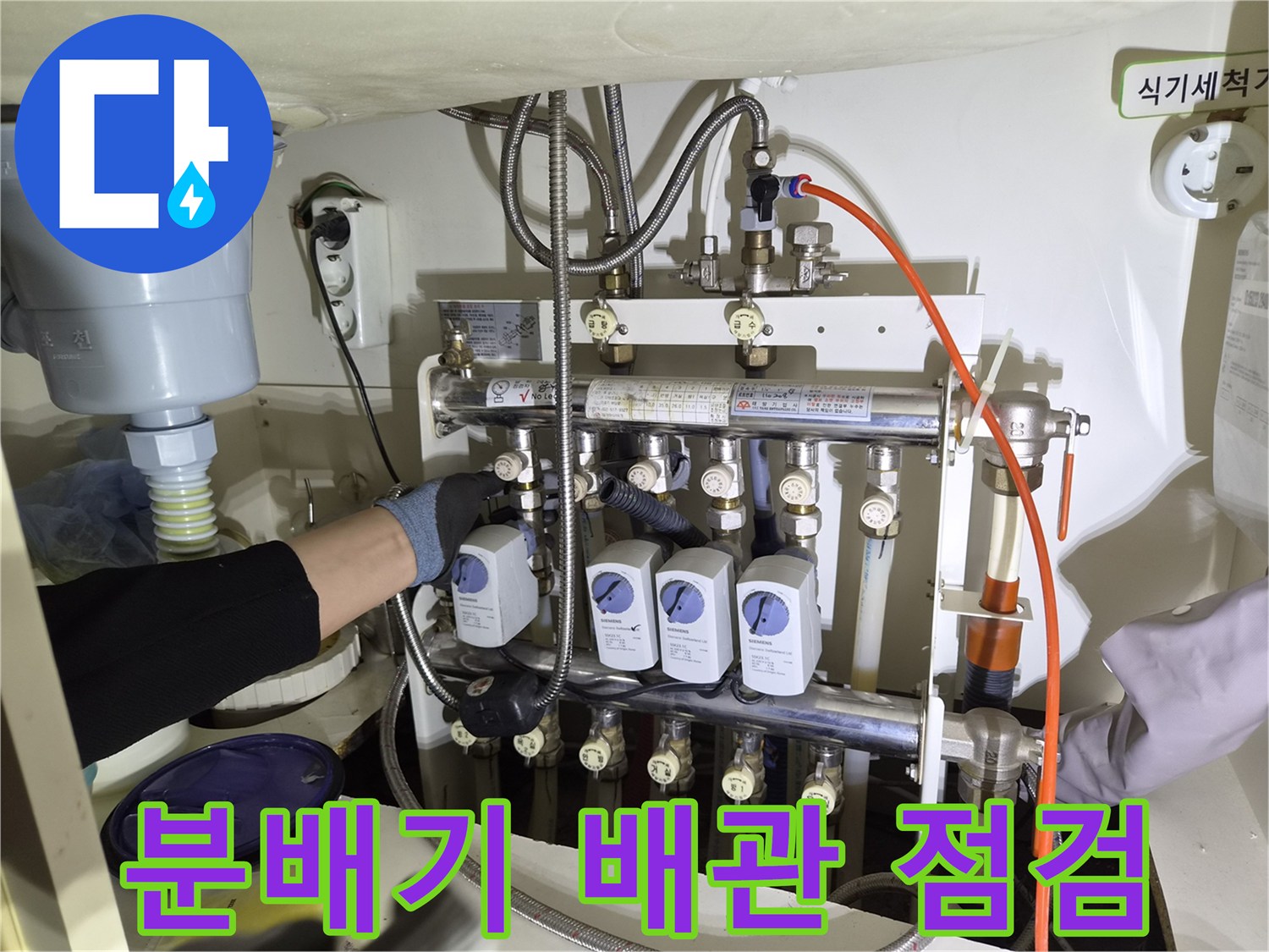 싱크대 하부장 내부 - 분배기 및 보일러 연결 배관 상태 확인 중