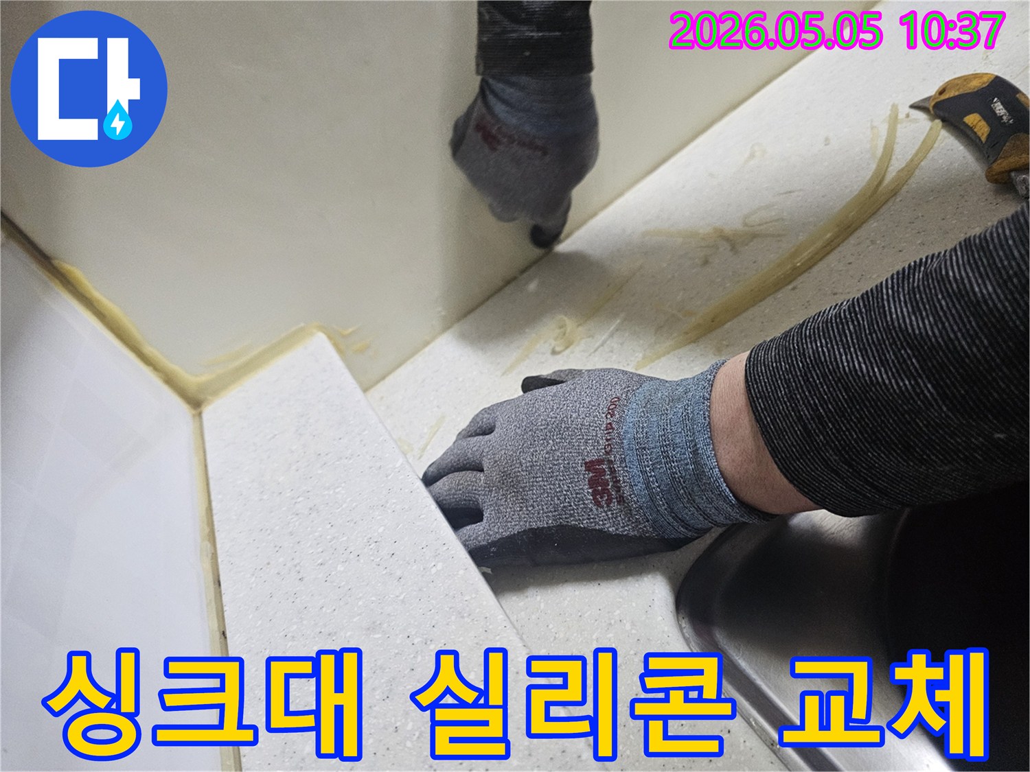 숙련된 전문가가 싱크대 주변의 물샘 원인인-오래된 실리콘을 제거하고-새로운 방수 실리콘으로 교체하는 작업 현장입니다