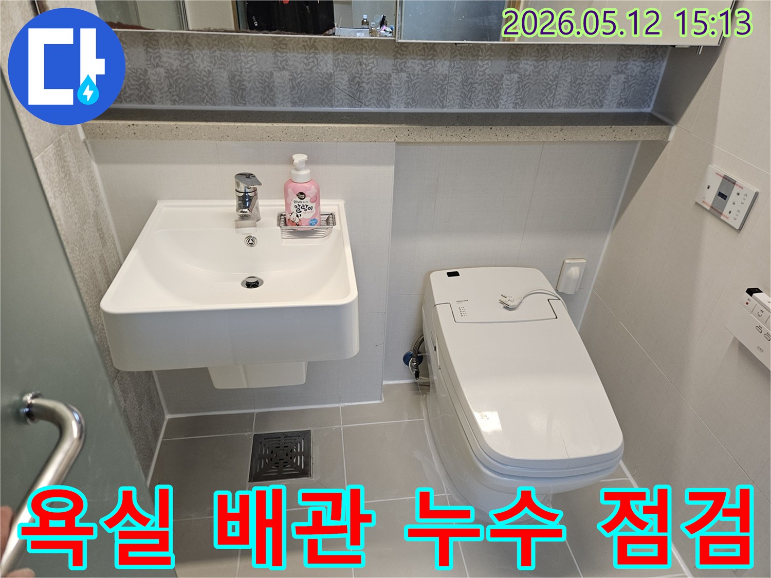 이 이미지는-김포 아파트 욕실의-세면대와 변기 하부-배관 연결 부위를-촬영한 것으로-배관 누수 여부를-점검하는-과정을 보여줍니다