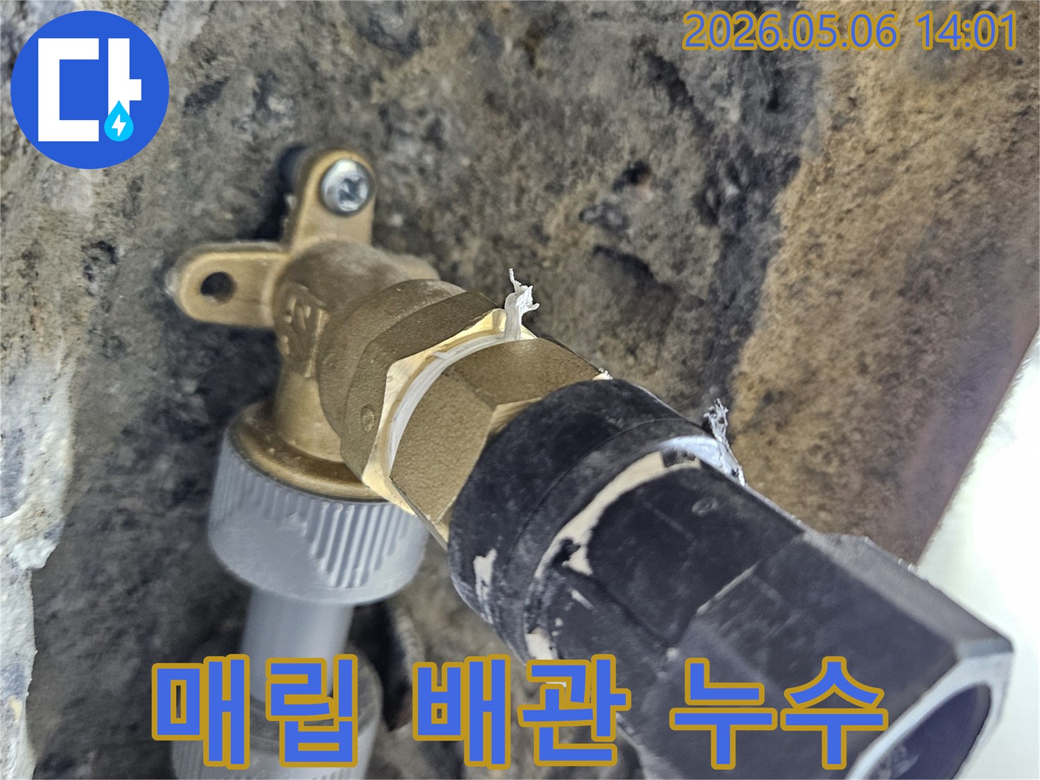 이 이미지는-콘크리트 벽면에-매립된-수도 배관의-연결 부위에서-누수가-발생하여-주변이-젖어있는-현장을-보여줍니다.