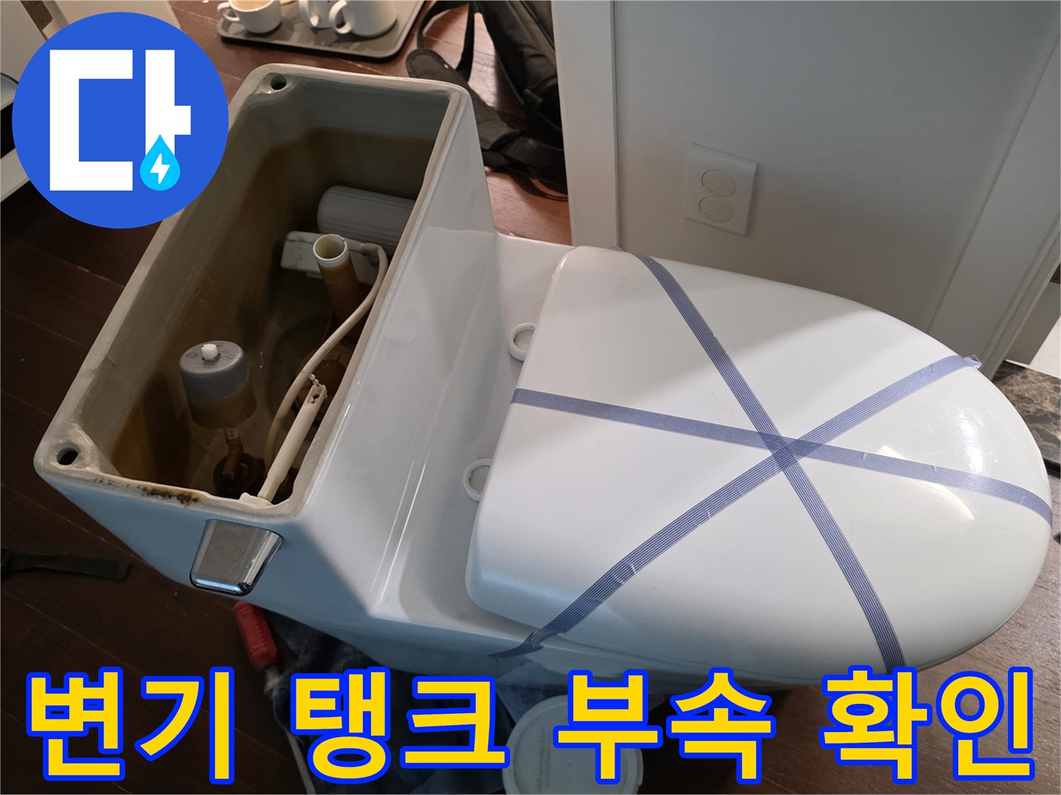 변기 탱크를 탈거하여 내부의 필밸브와 연결관을 관찰하는 모습