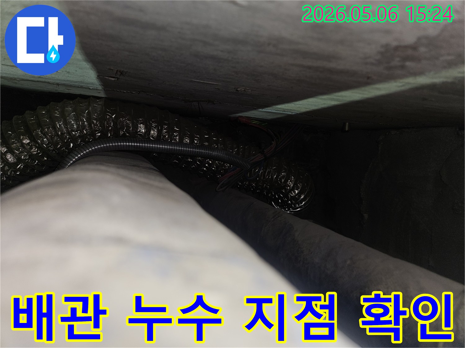 어둡고-협소한 공간에서-누수 원인이 될 수 있는-배관과-전선이-함께-지나가는-모습을-촬영한-사진입니다