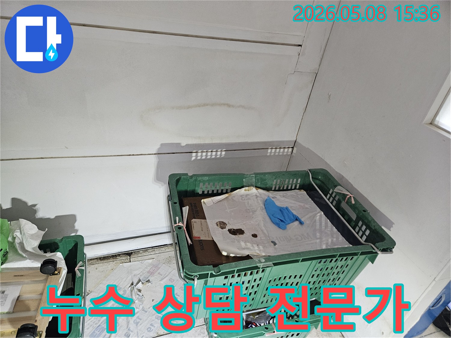 천안 목천읍의 건물 내부에서-누수 흔적이 발견된 천장과 벽면 모서리를-전문가가 진단하며-고객에게 친절하고 정확한 상담을 제공하는 모습