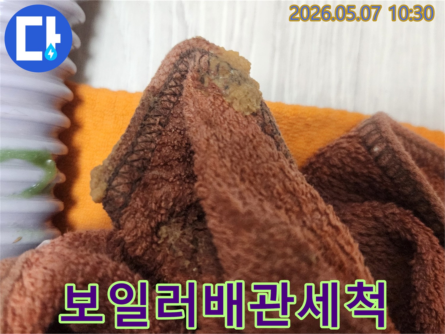 보일러-누수-탐지-중-배관-연결부의-오염물을-제거하는-작업-사진입니다