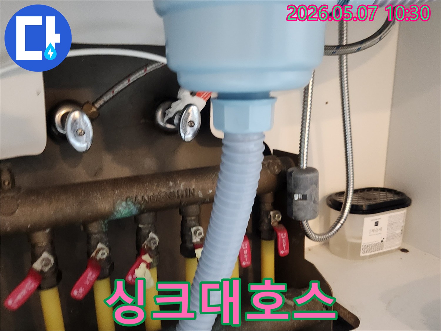 새로운 싱크대 배수 호스가-기존 배관에-깔끔하게 연결되어-누수 걱정을-덜어주는 모습입니다.
