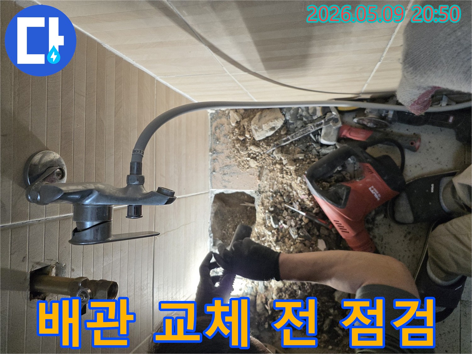 이 이미지는-성남 수정구의 한 빌라에서-욕실 누수 해결을 위해-배관 교체 작업을 시작하기 전-숙련된 엔지니어가-기존 배관 상태를-꼼꼼히 점검하는 과정을 보여줍니다.