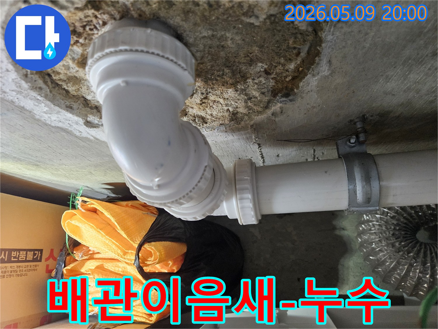 상가 건물 천장에 설치된 배관의-이음새 부분에서-누수 여부를 확인하기 위해-전문 엔지니어가 점검하는 모습입니다