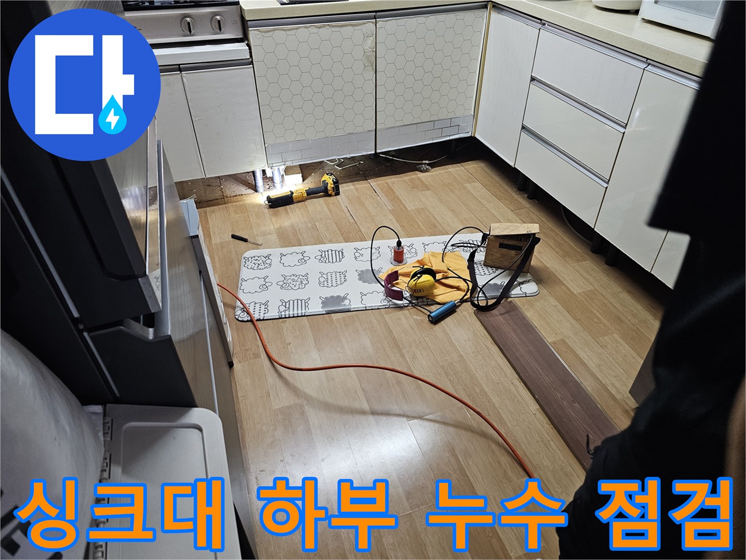 주방 싱크대 하단 배관의 물샘 지점을 찾기 위해 정밀 장비를 배치한 모습입니다.