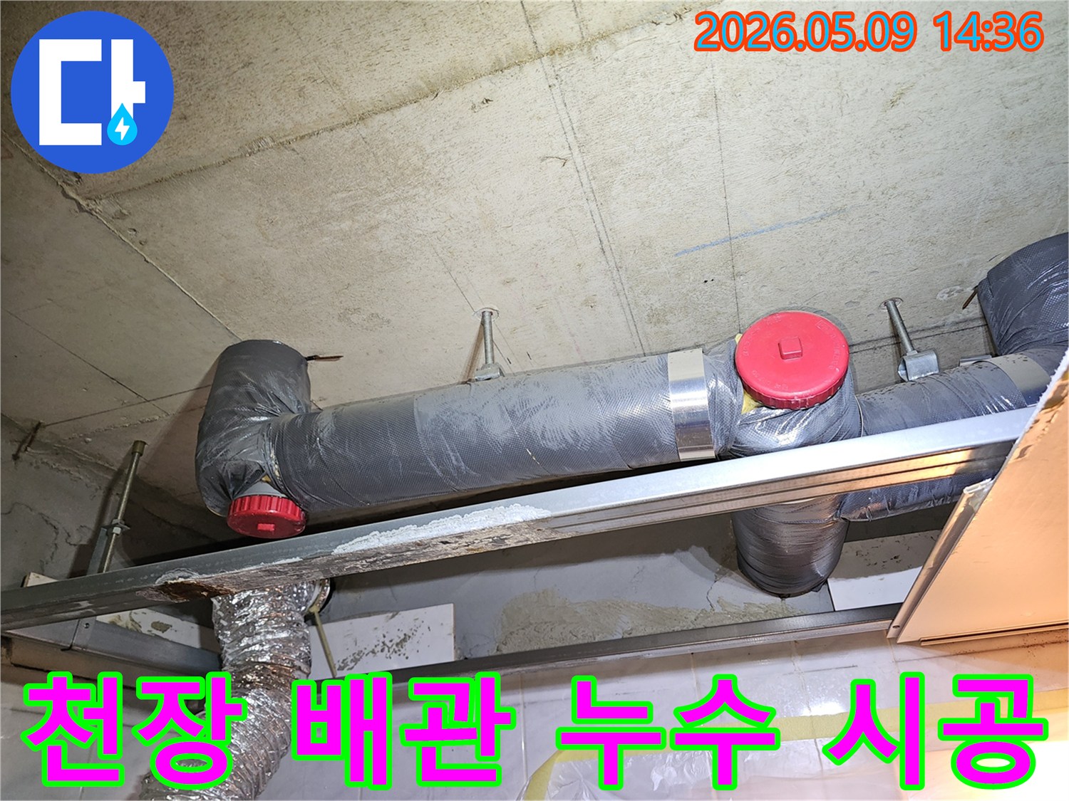천장 배관에서 발생한 누수를 해결하기 위해-전문가가 보수 작업을 준비하고 있는 모습입니다