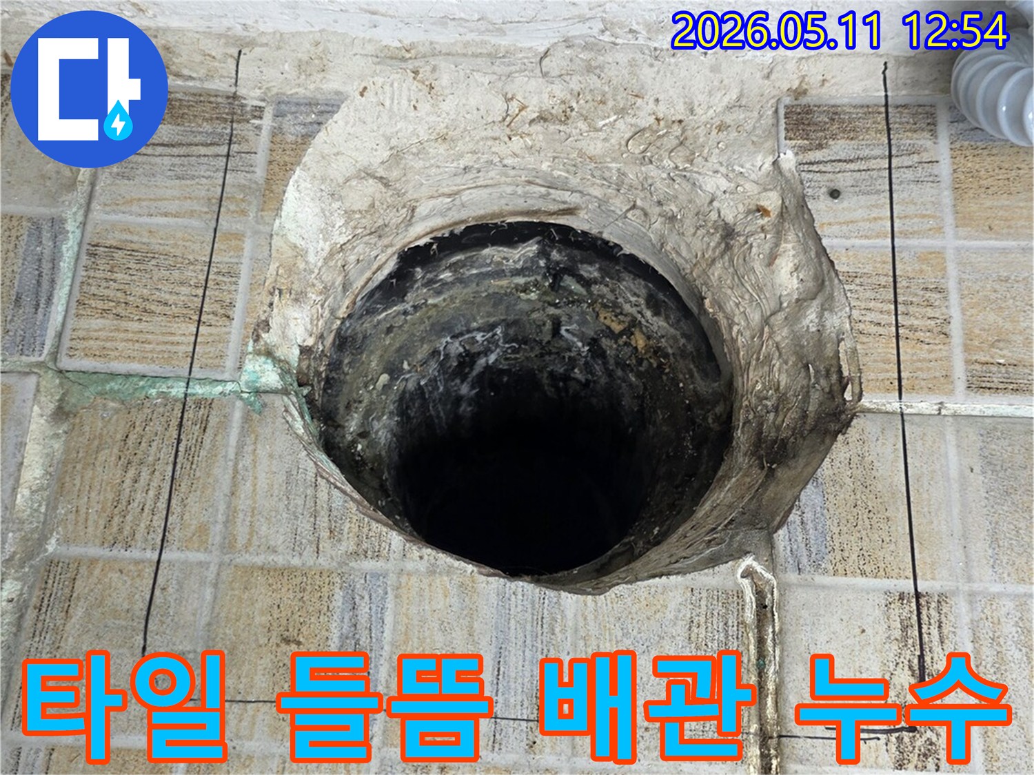 이 이미지는-서울 양천구 빌라에서-발견된-누수로 인한-배관 주변 타일 들뜸 현장을-보여주며-해결 작업을 위한-확인 모습입니다