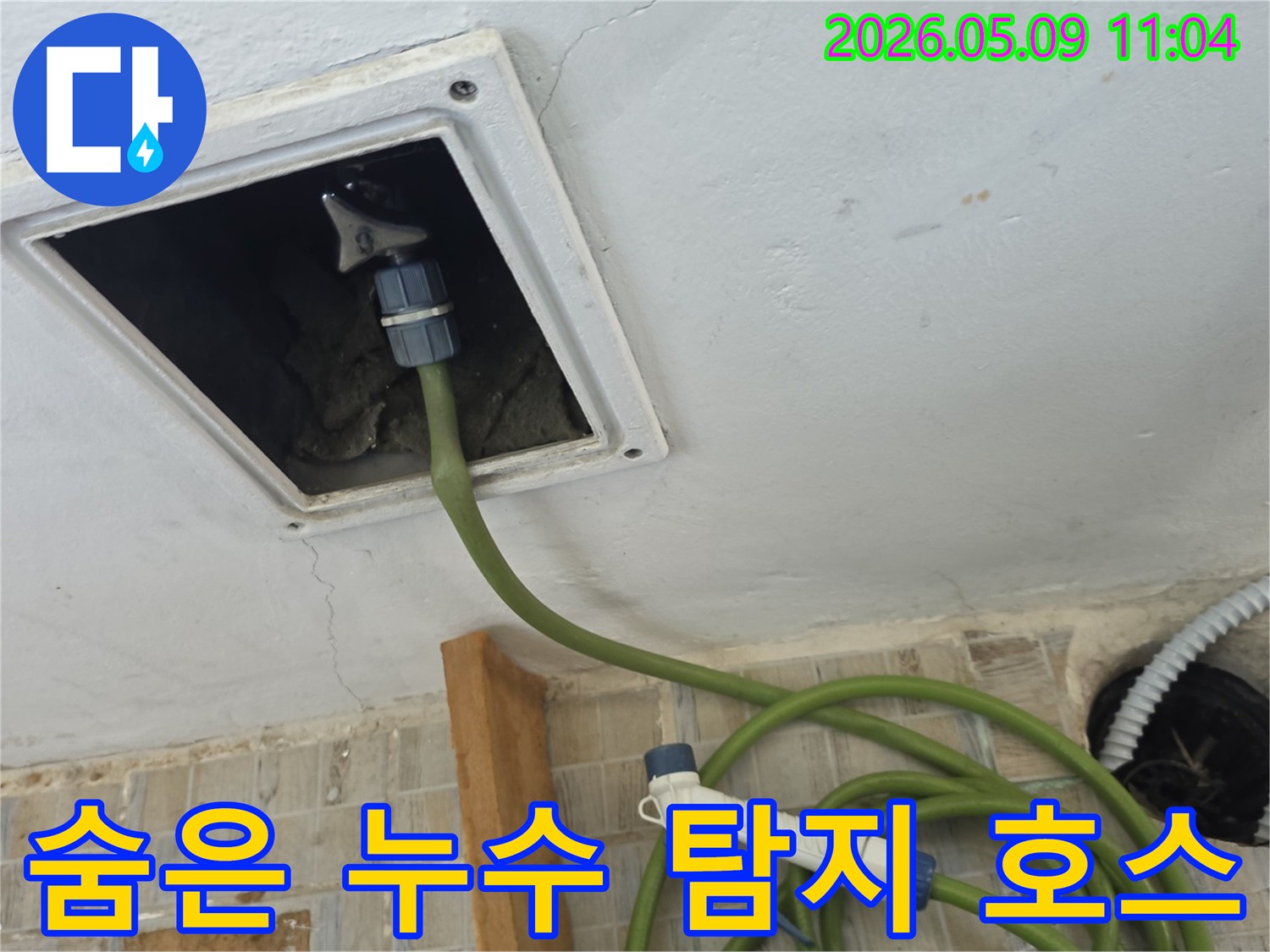 천장 점검구에 누수 탐지 호스를 연결하여 보이지 않는 곳의 누수 문제를 해결하기 위한 작업