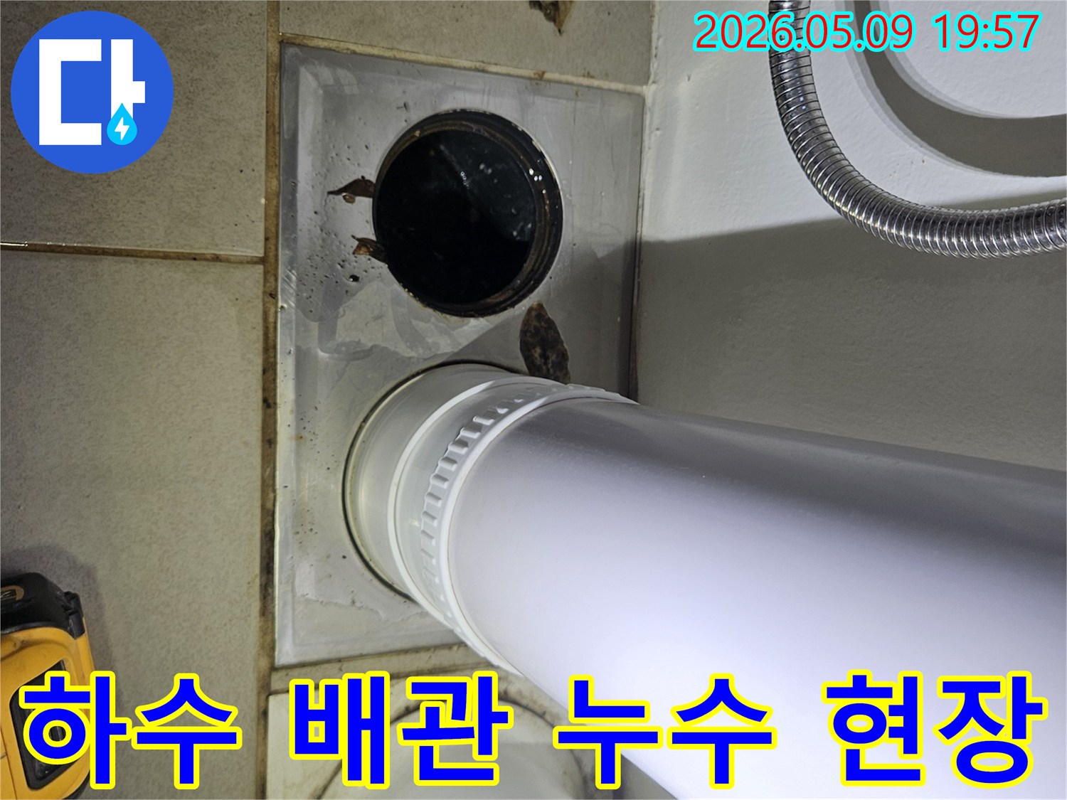 이 사진은 욕실 바닥의 하수 배관 주변에서 발생한 물 고임과 오염 현장을 보여주며-긴급한 조치가 필요함을 시사합니다.