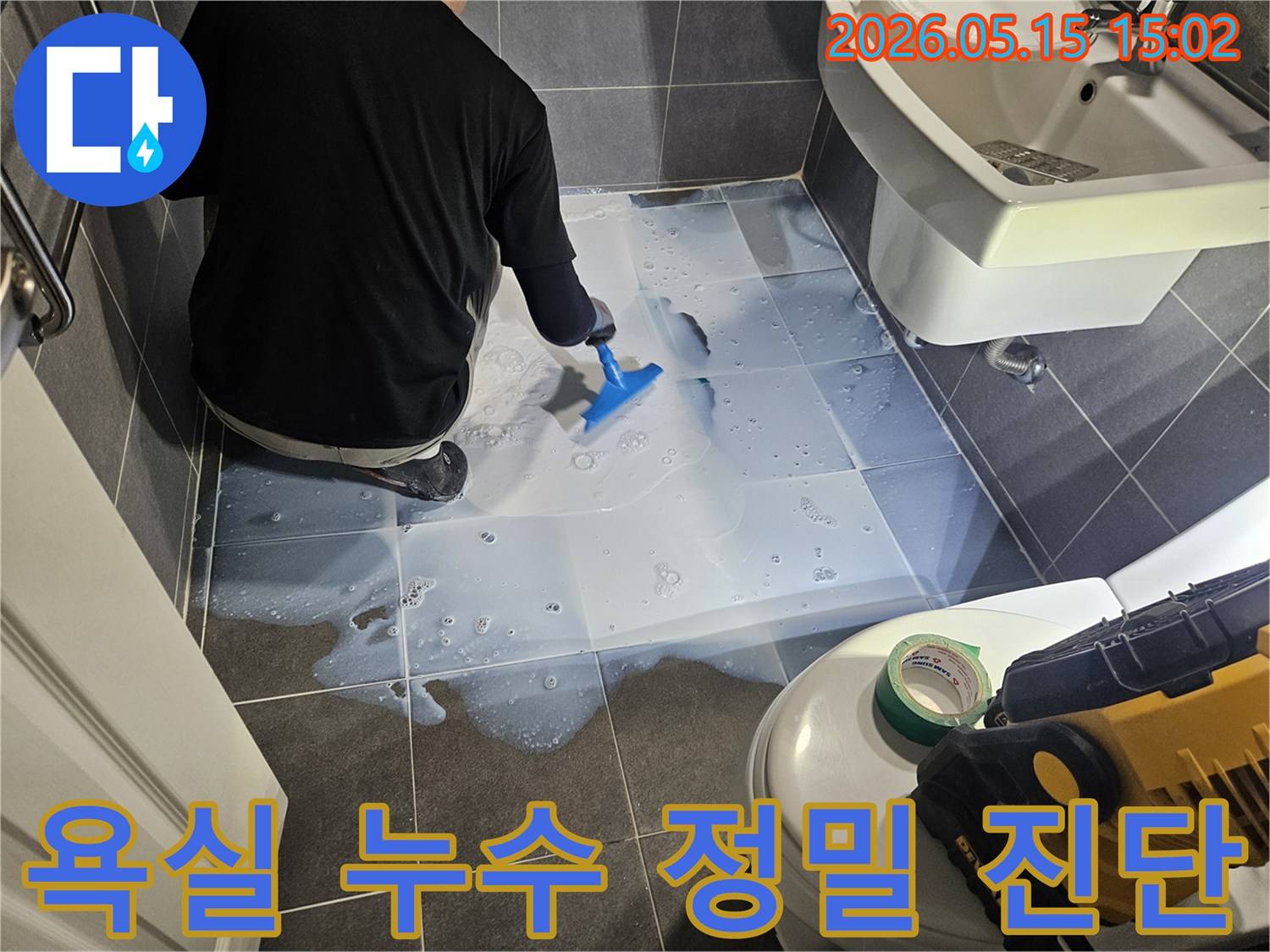 누수 전문가가-욕실 바닥에-누수 탐지액을 고르게 도포하며-미세한 누수 지점을-찾아내고 있습니다.