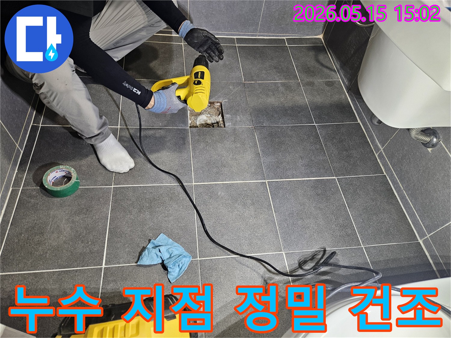 숙련된 엔지니어가-화장실 바닥의-누수 지점을-발견한 후-주변 습기를-완벽하게 제거하기 위해-정밀 건조 작업을-진행하고 있습니다.